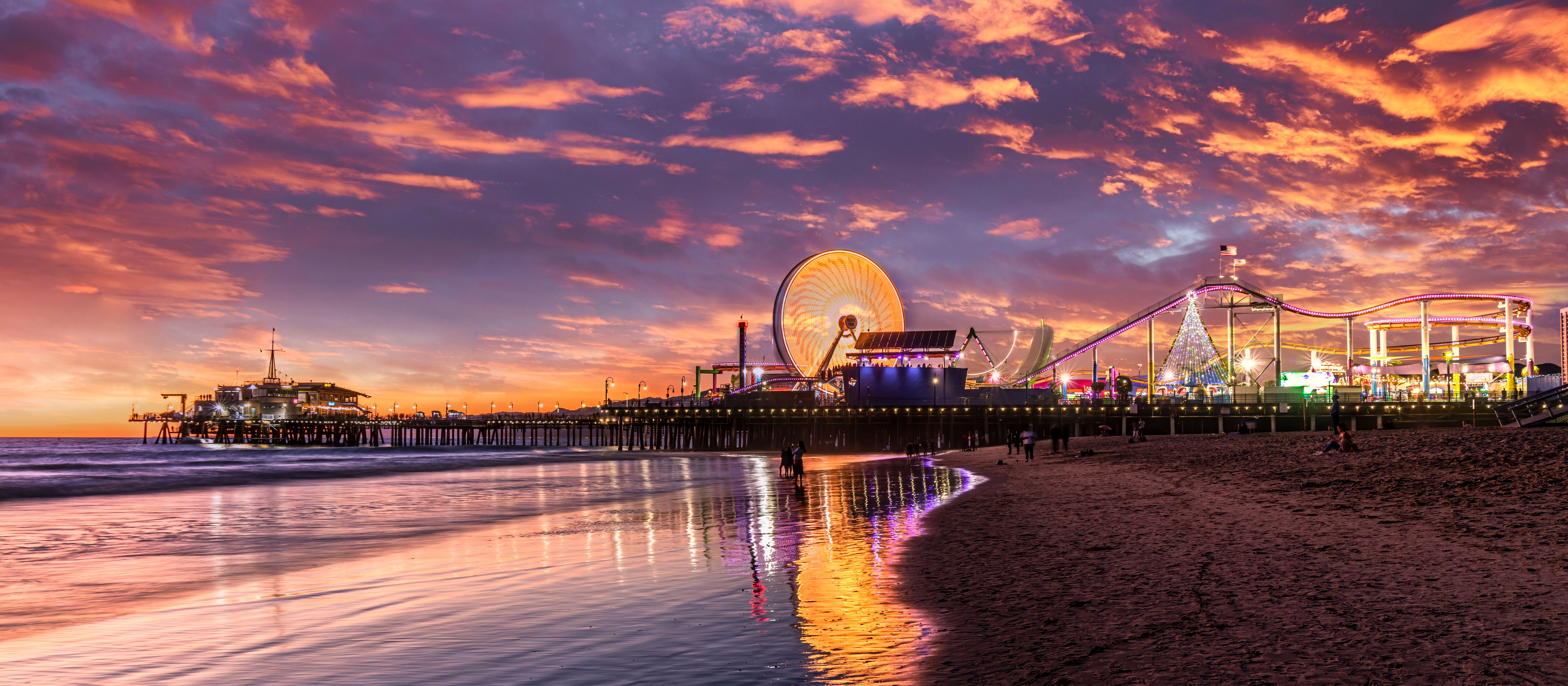California's Santa Monica Pier and beach lit up as the sun sets
