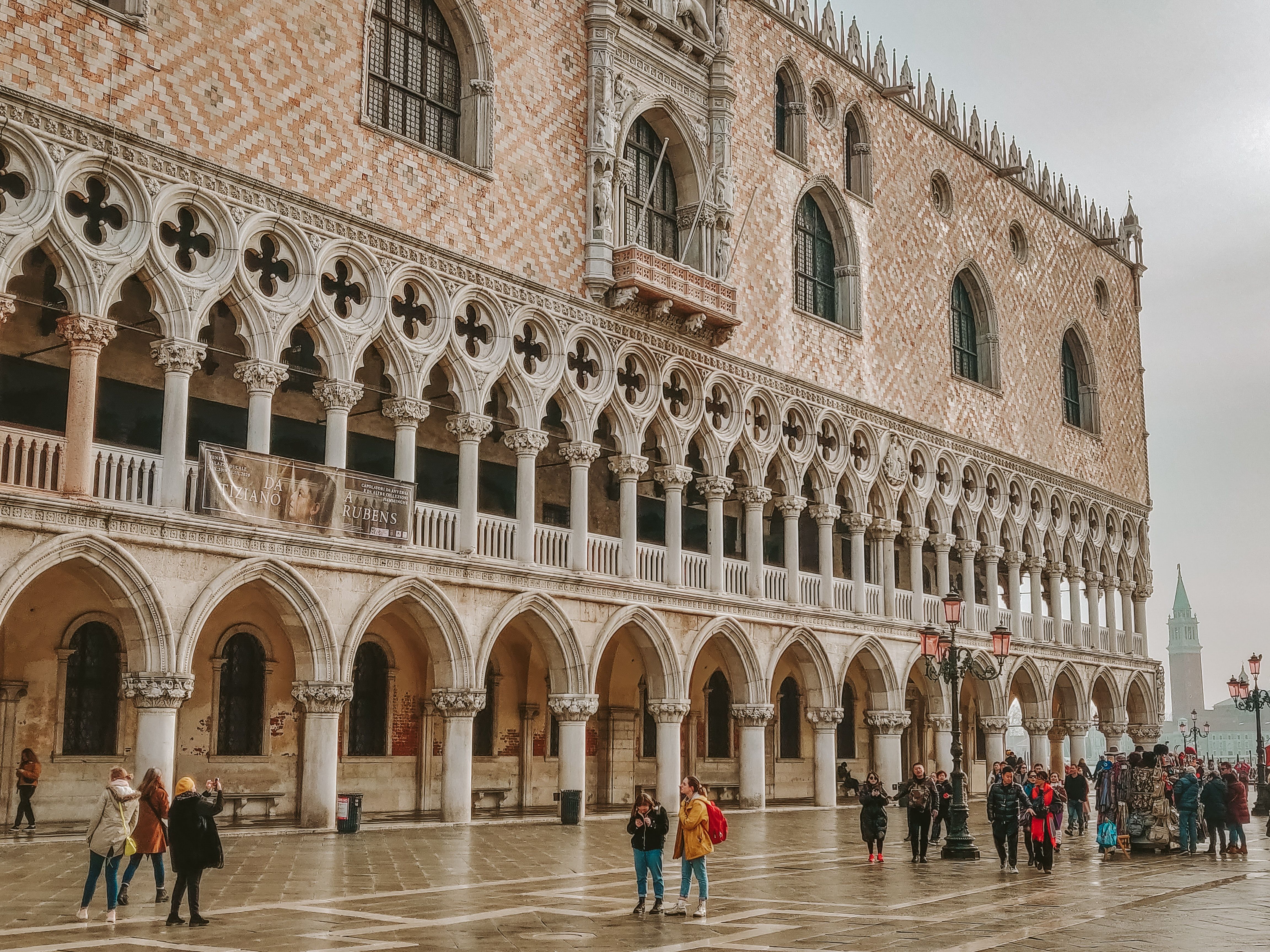 Tourists stroll by the Doge's Palace in Venice