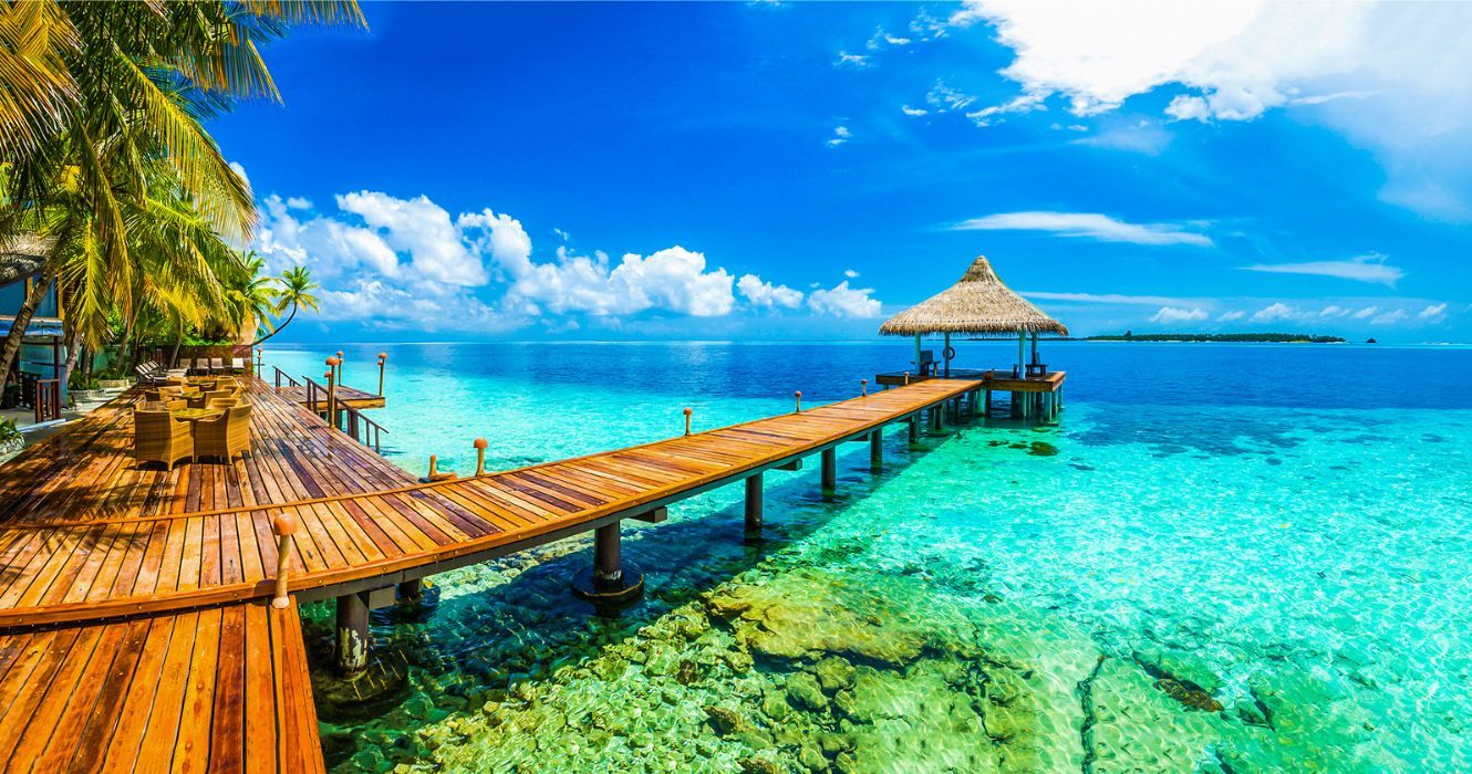 a dock on a beach in the maldives
