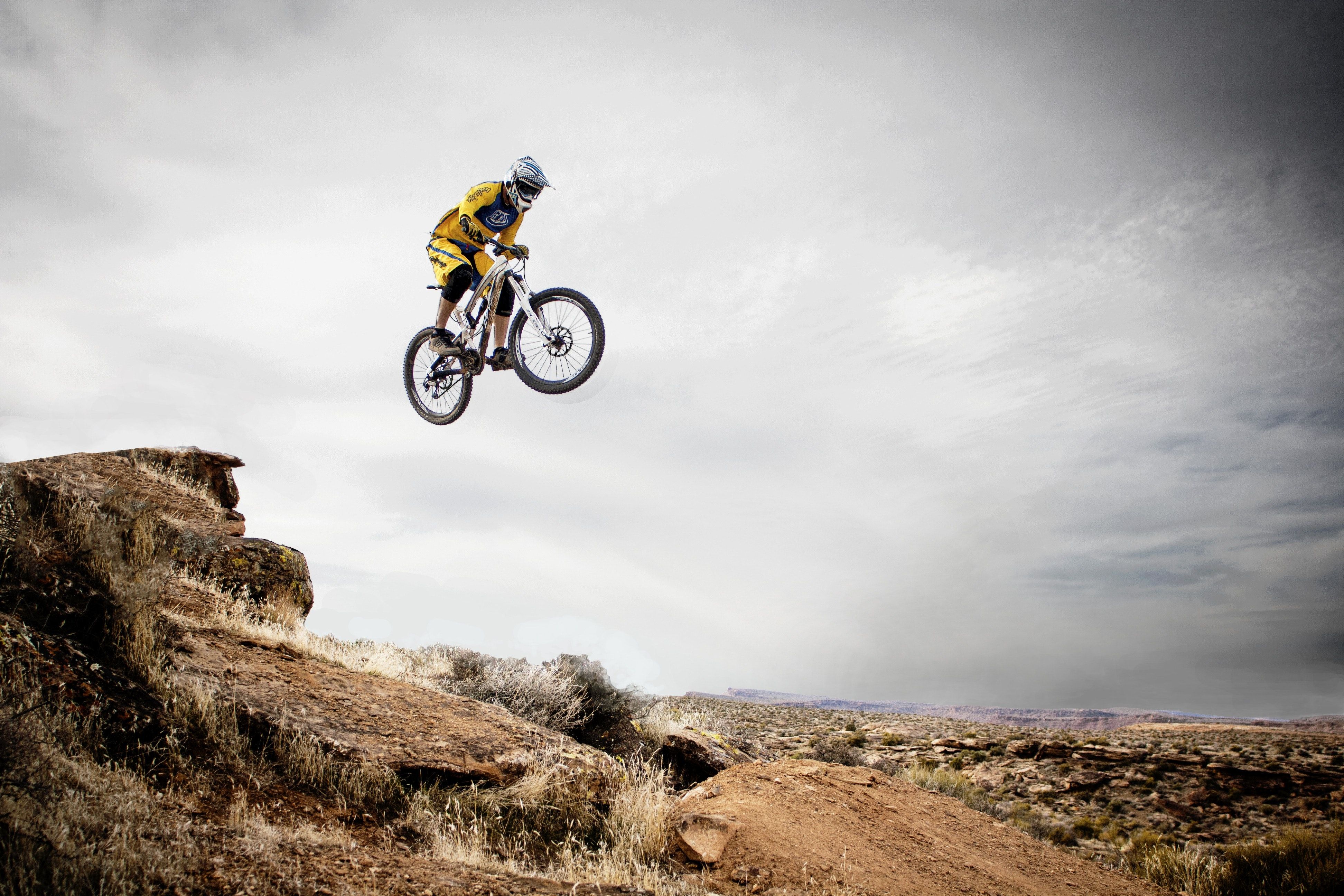 A Man Biking In A Rugged Landscape.