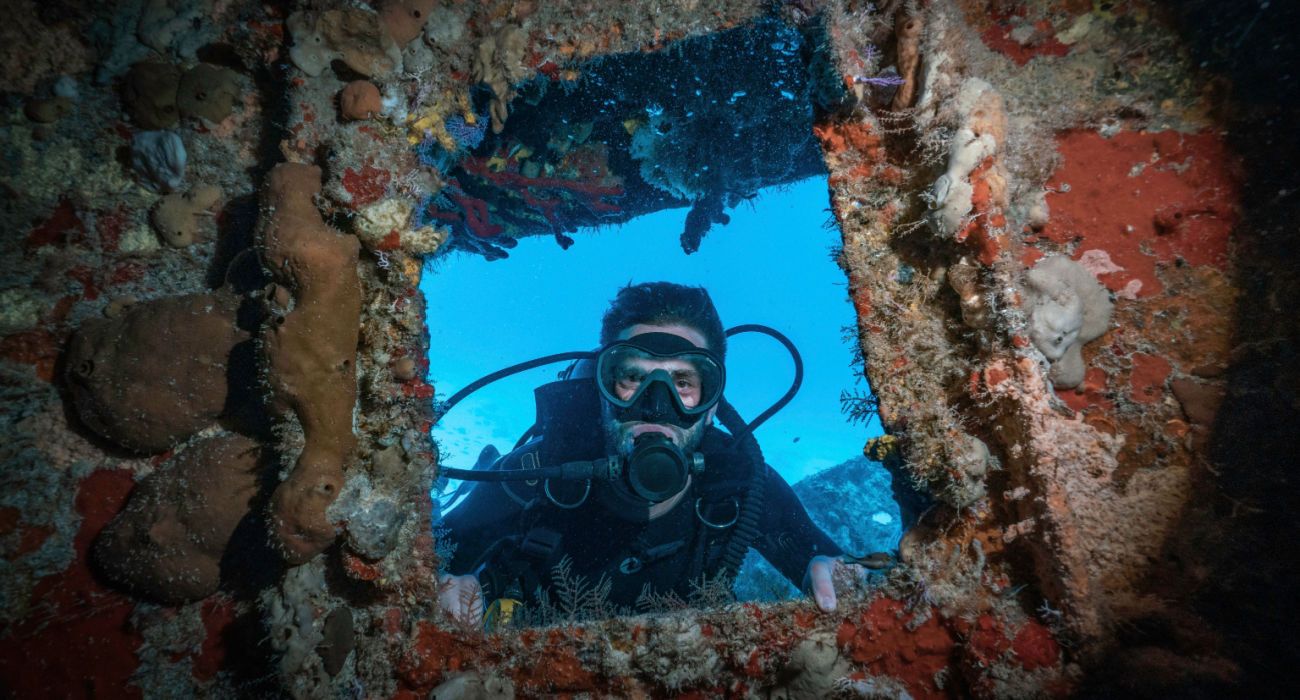 Scuba diver posing in a coral window
