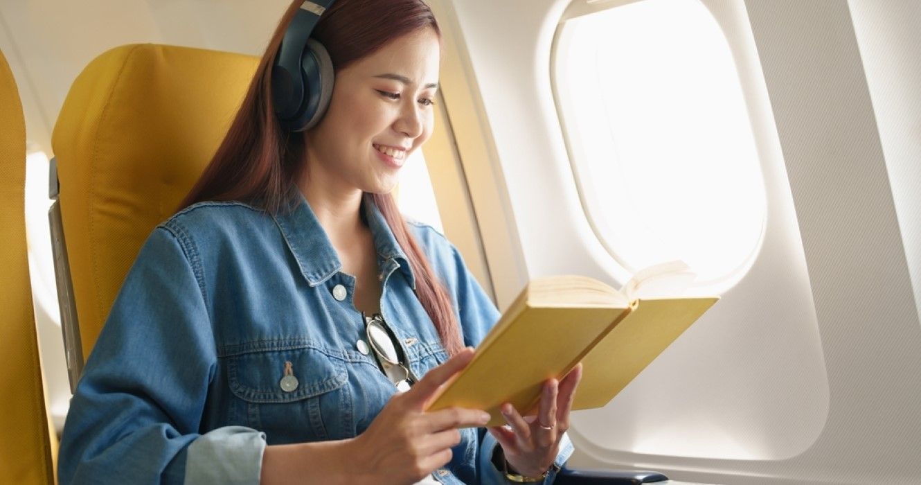https://static1.thetravelimages.com/wordpress/wp-content/uploads/2023/01/woman-sitting-in-a-window-seat-in-economy-class-reading-a-book.jpg