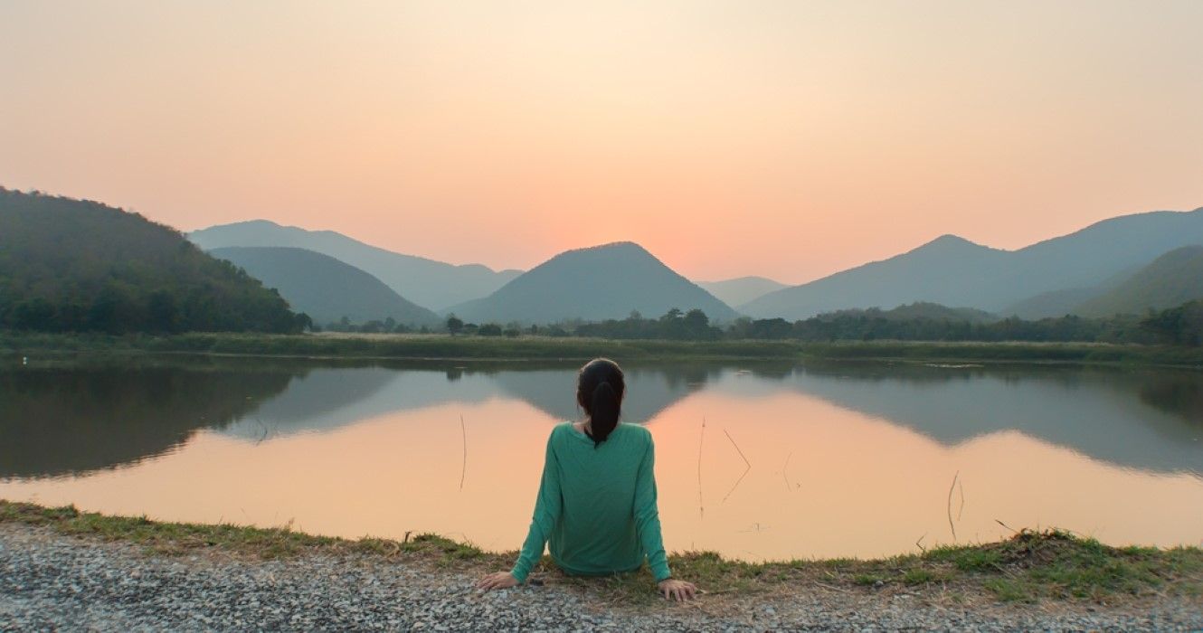 Woman traveling alone and sitting by the lake