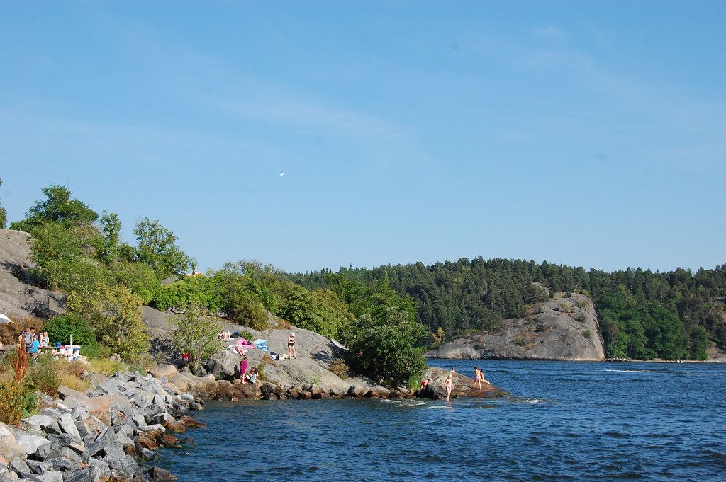 People Sunbathing At A Baltic Sea Beach In Fjäderholmarna Island In Sweden