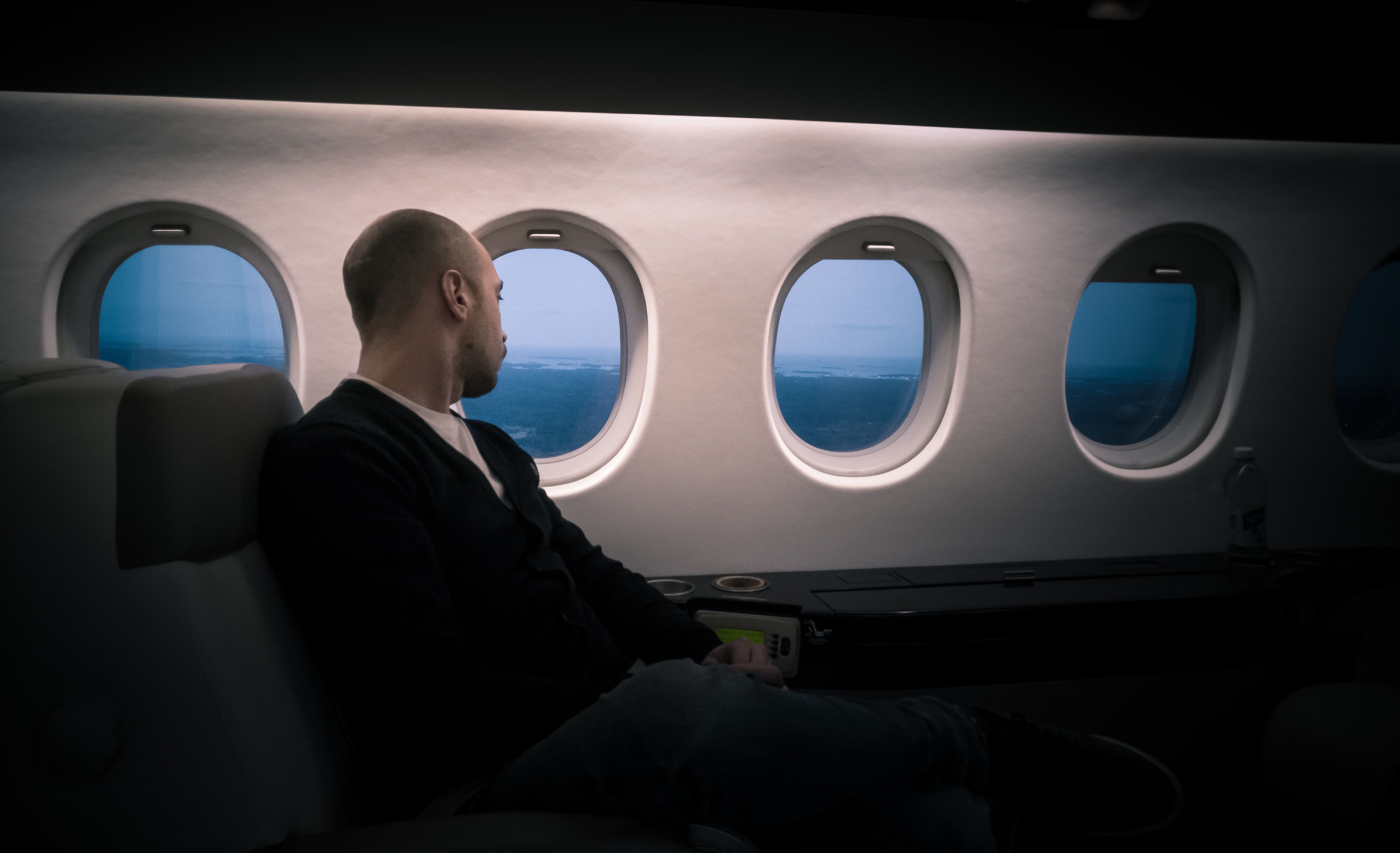 A man sitting by the window of a flying plane