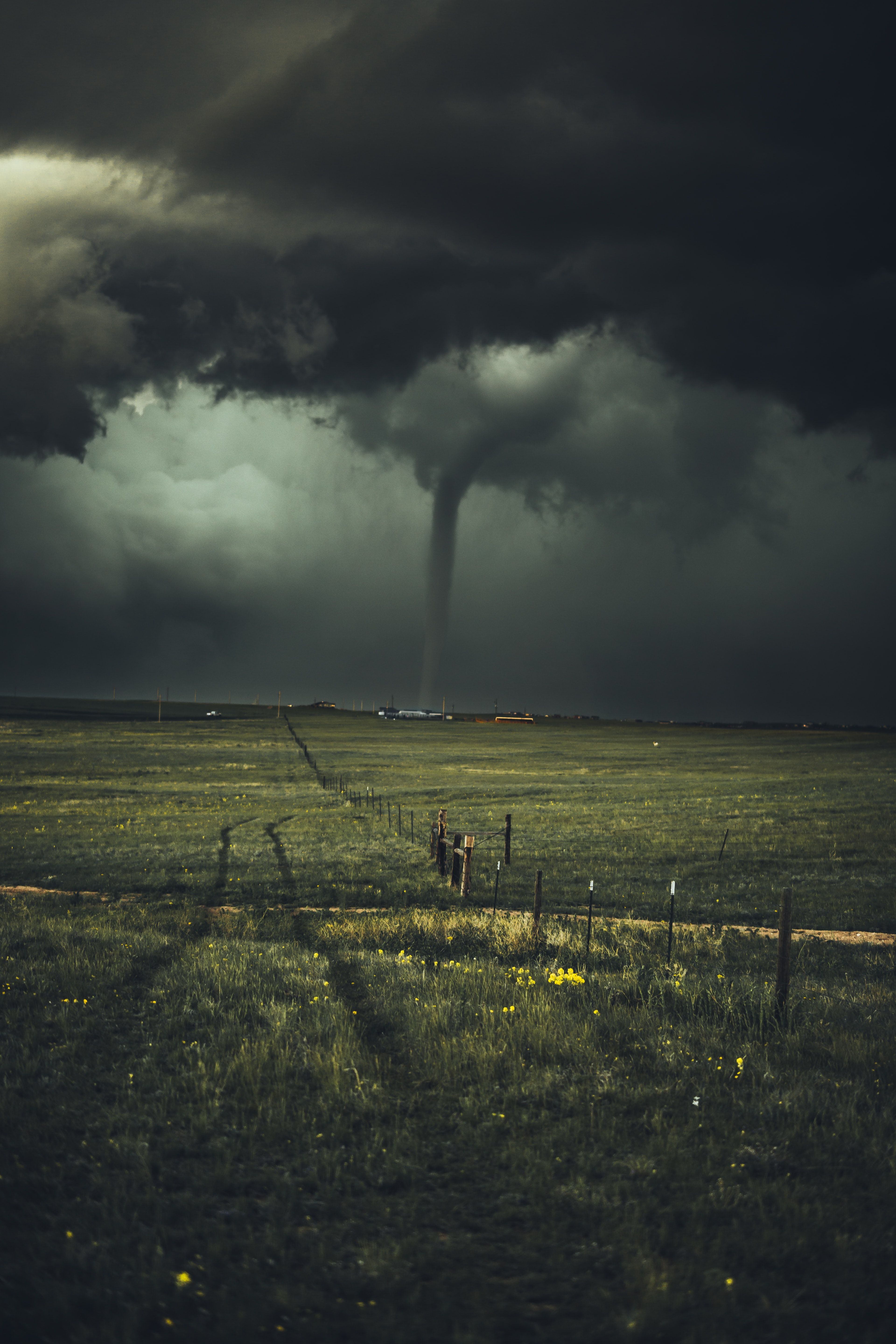 A tornado with dark clouds touching the earth