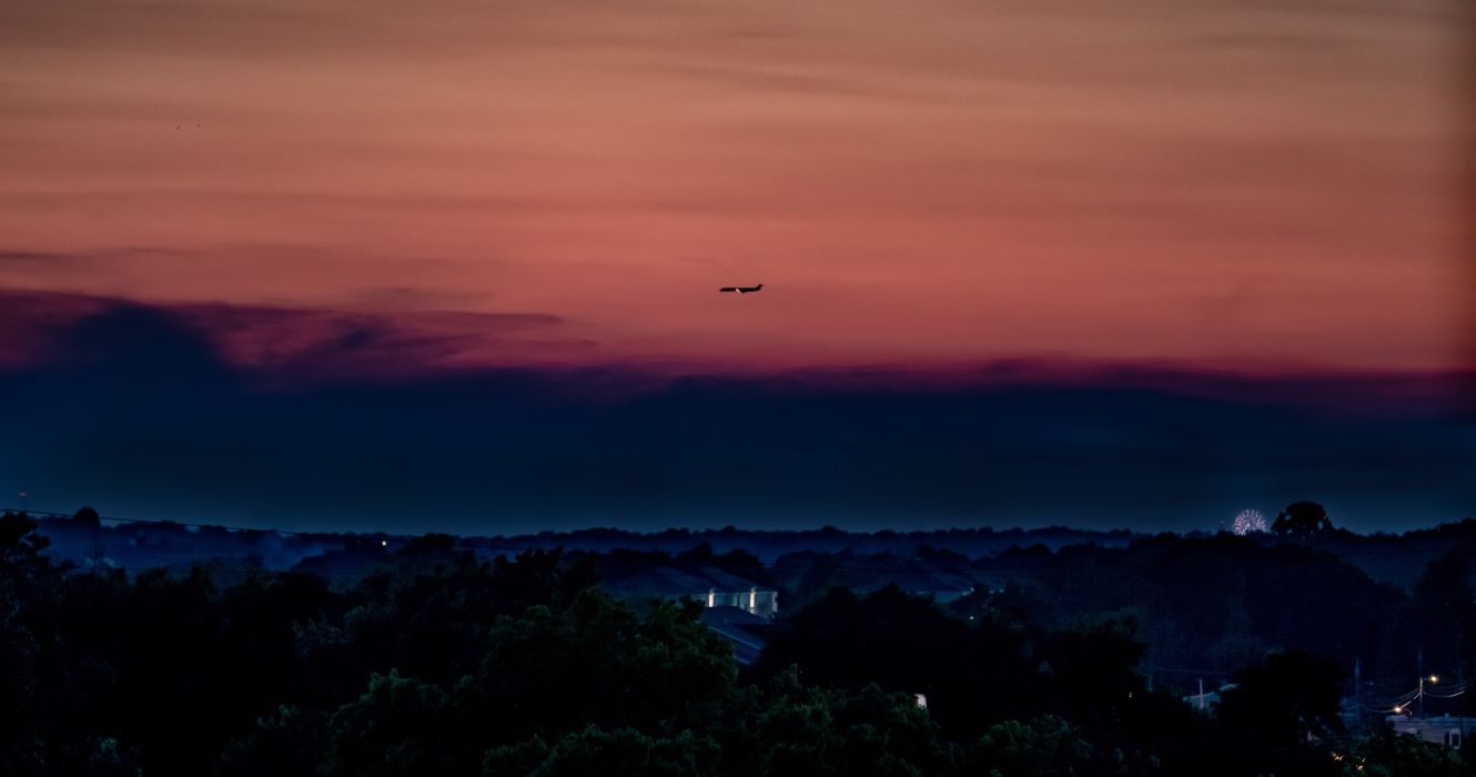 Plane flying over Lexington at dusk