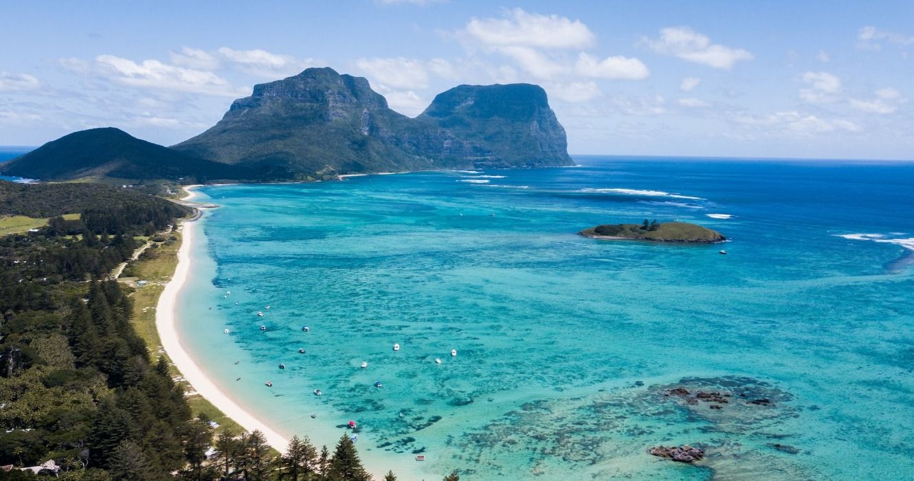 A beautiful, sunny day over Lord Howe Island in Australia, showing Lagoon Beach and its aqua blue coral waters.