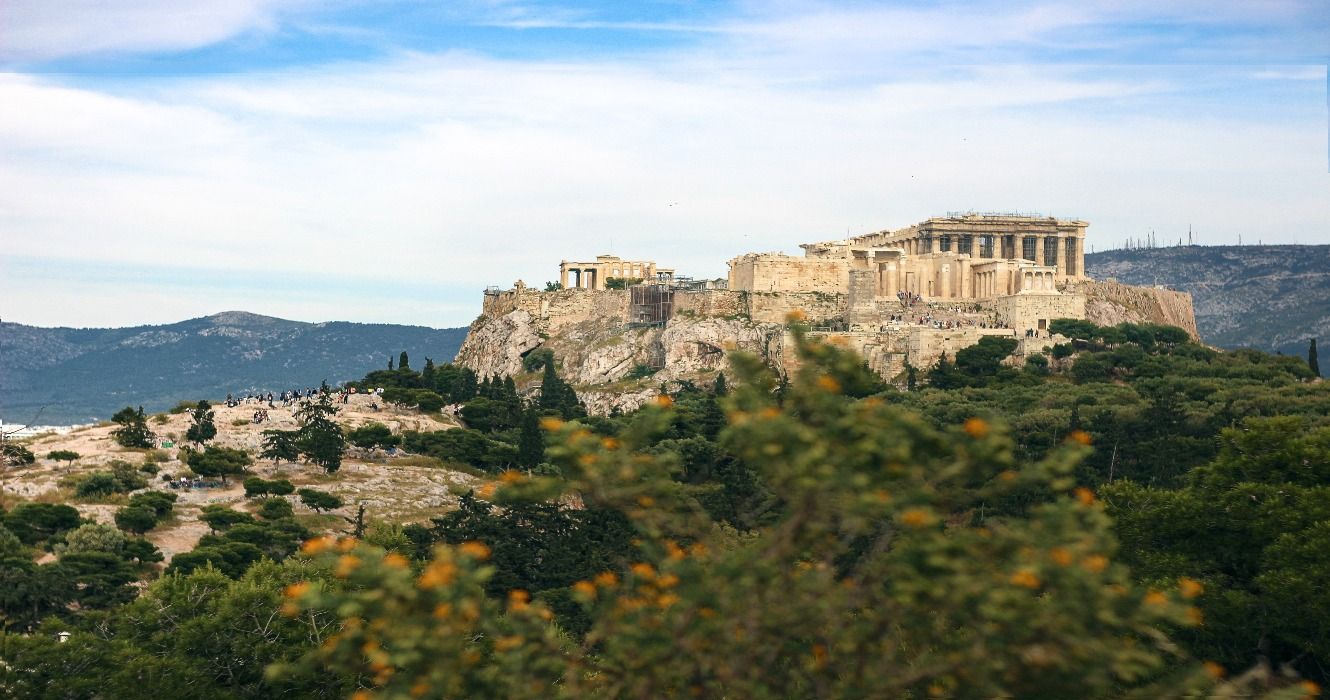 The Pnyx Acropolys on Areopagus Hill in Athens, Greece, with lush green foliage surrounding the historical structure