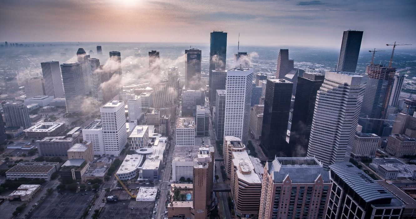 An aerial view of Houston city center with clouds hovering over the many skyscrapers