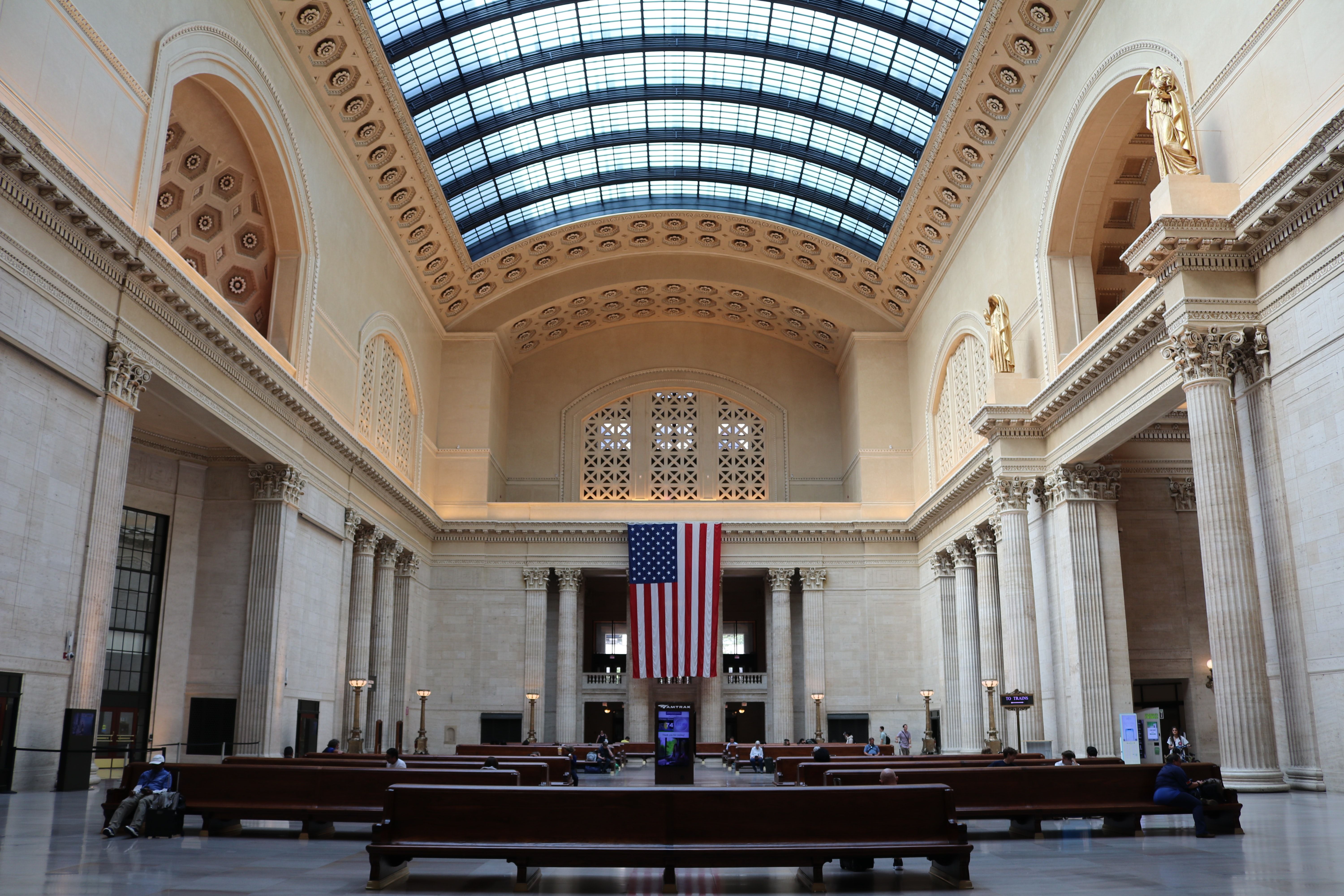 Union Station interior bright ceiling showing the sky American flag hangs in background.
