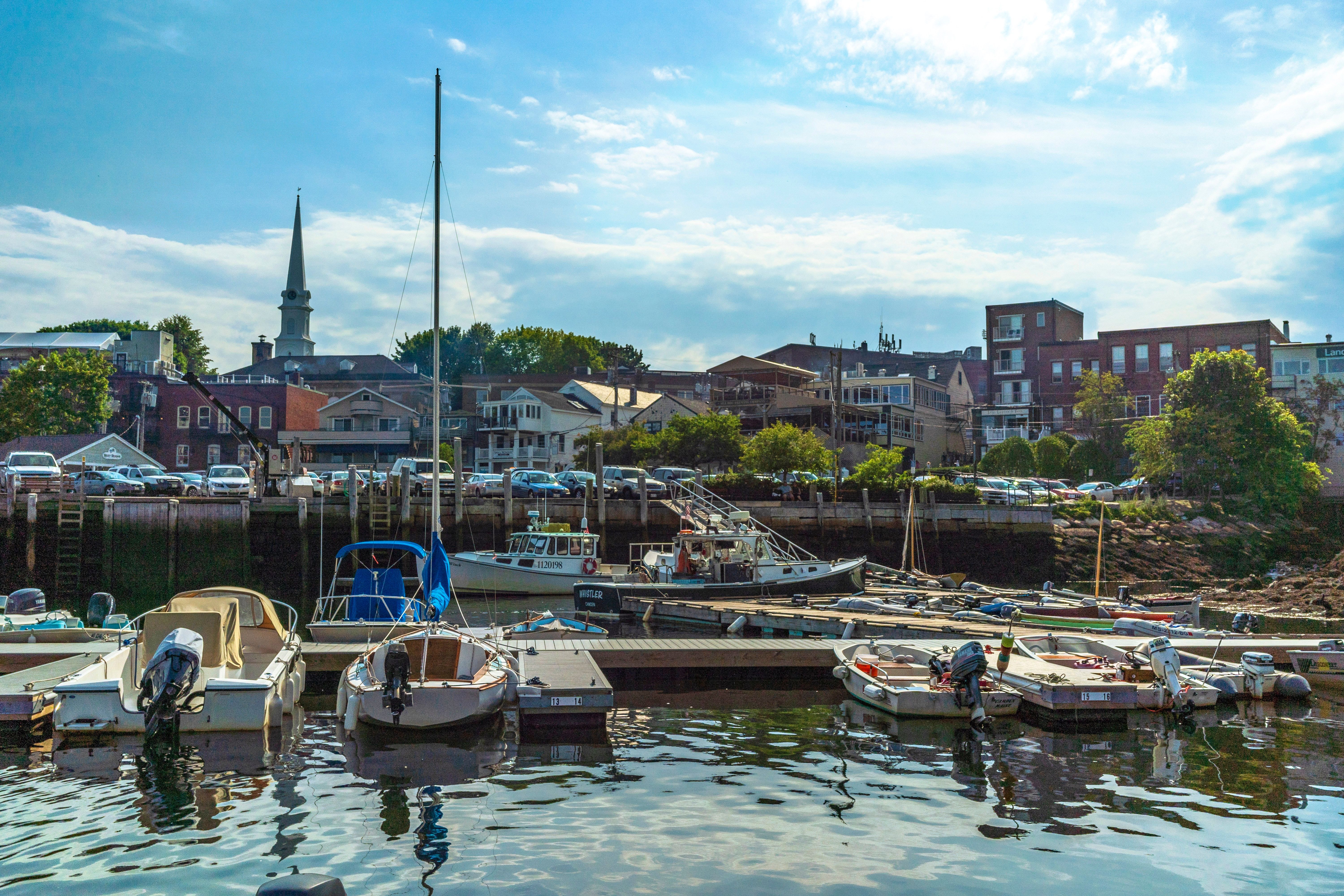 Camden Harbor with docked boats and buildings under a cloudy sky in Camden, Maine 