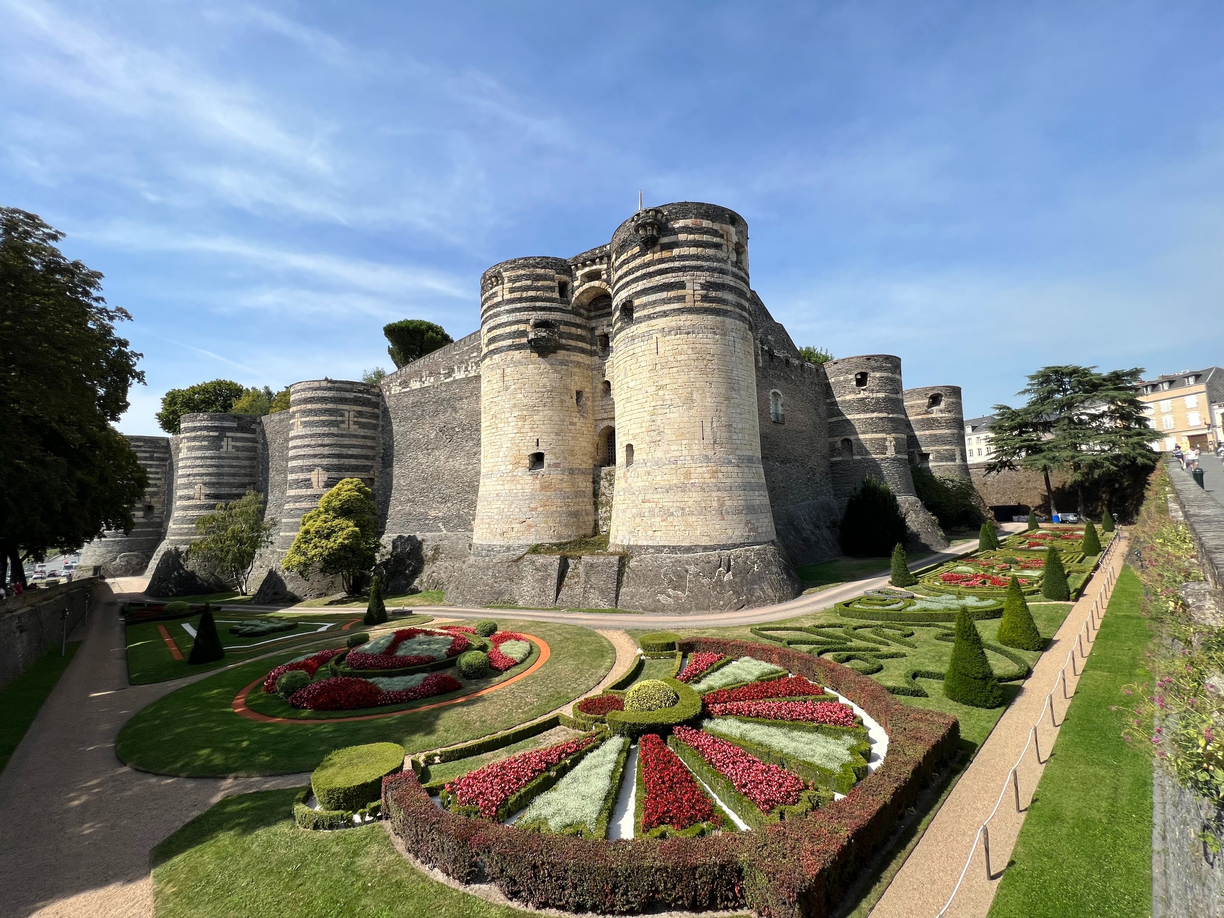 Château de Angers durante o dia, com jardins e fortaleza visíveis