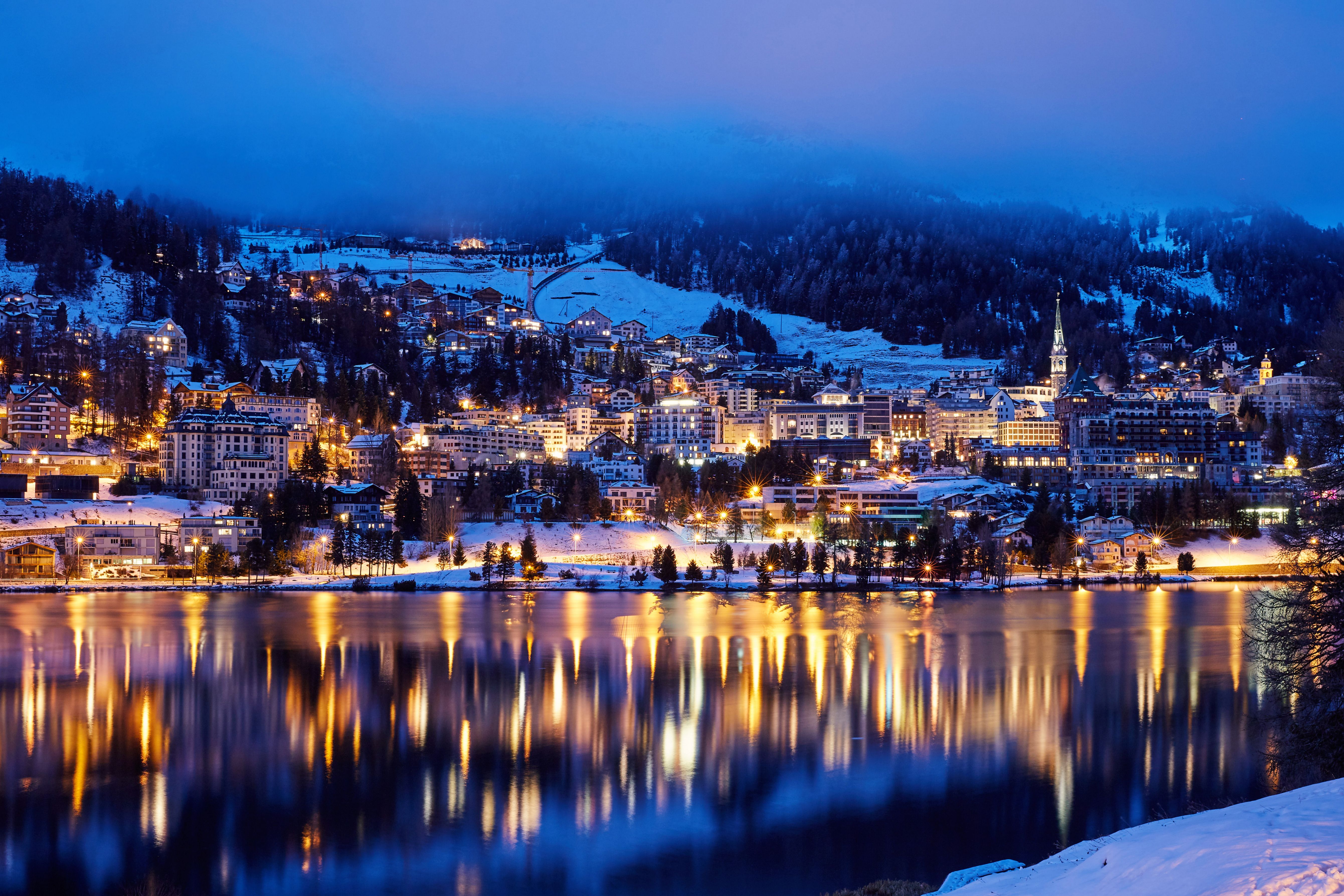 St. Moritz Resort town at night with light reflecting on the lake, Swiss Alps, Switzterland
