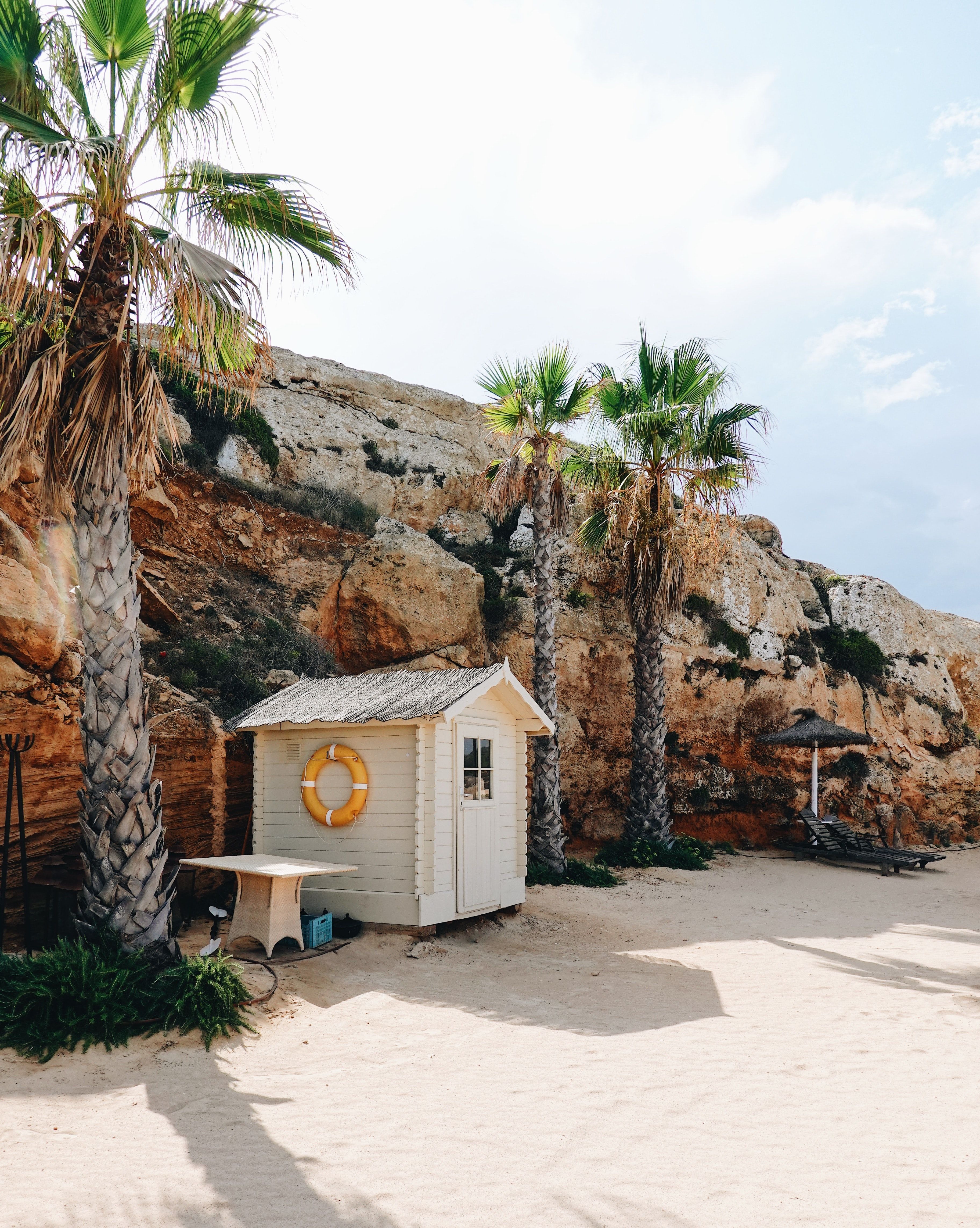 Uma cabana de praia em uma praia de areia branca com palmeiras em Mallorca, Espanha