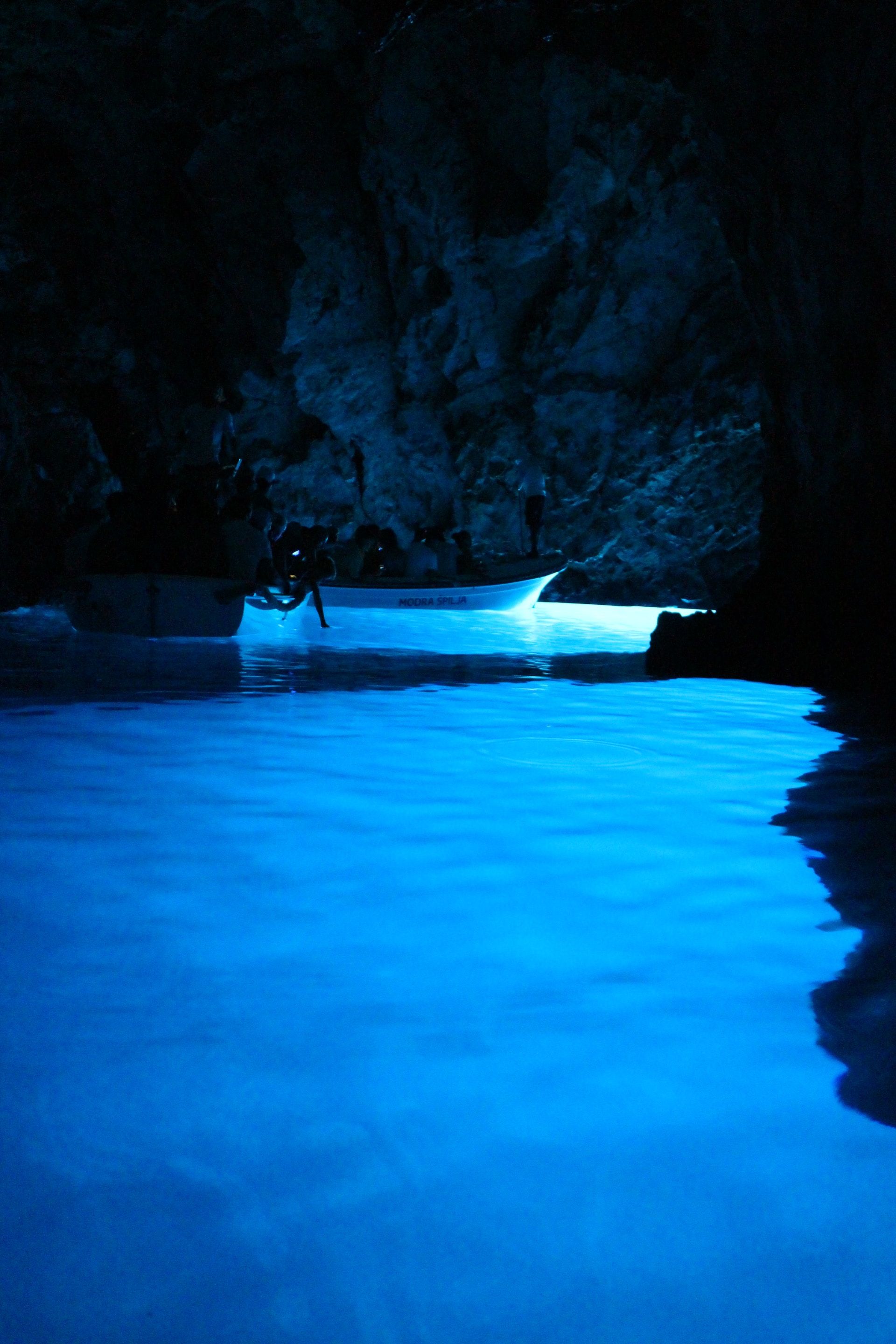 Caverna de mar azul alagado com um barco flutuando na água
