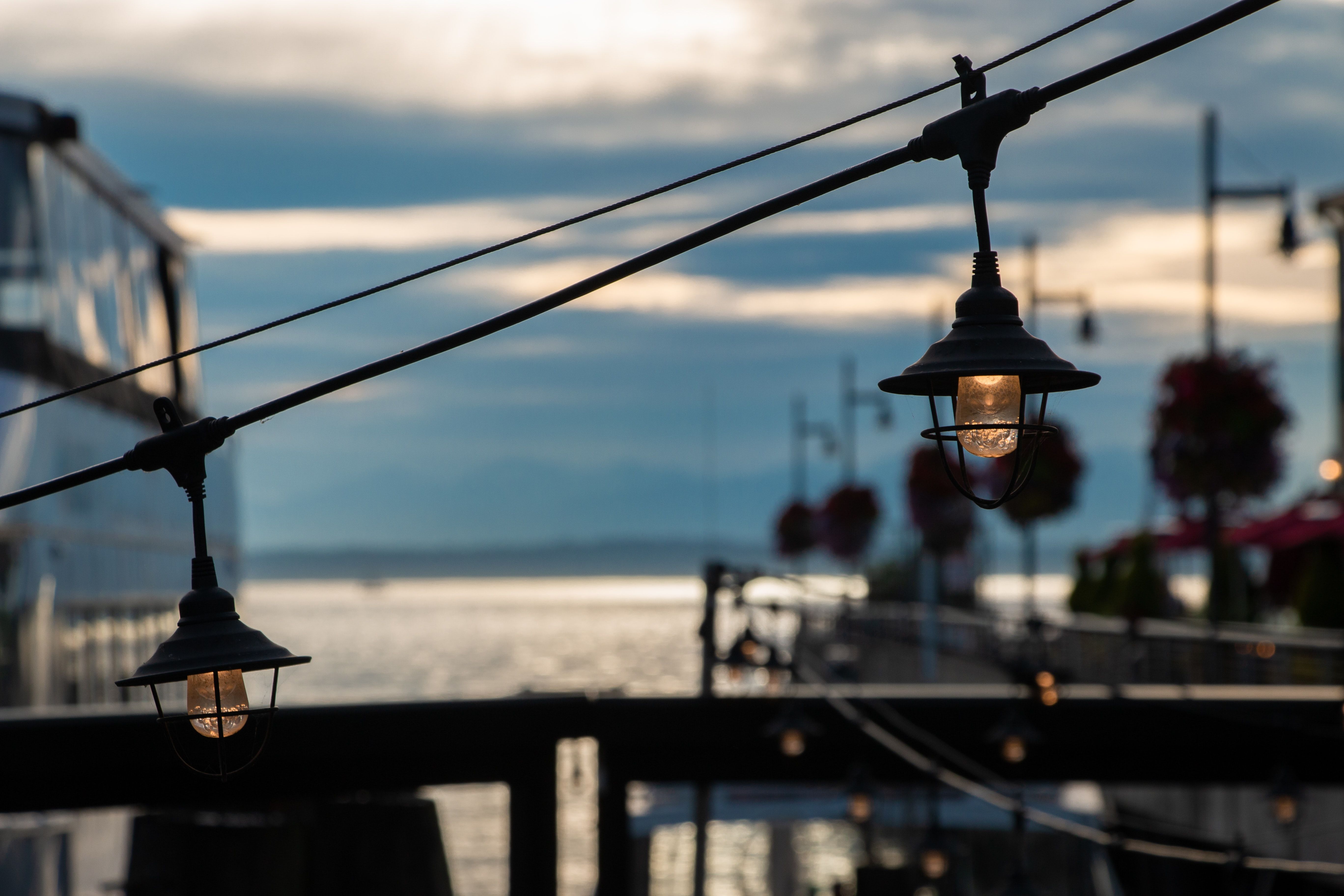 Boardwalk in Seattle with lights in focus and horizon in background