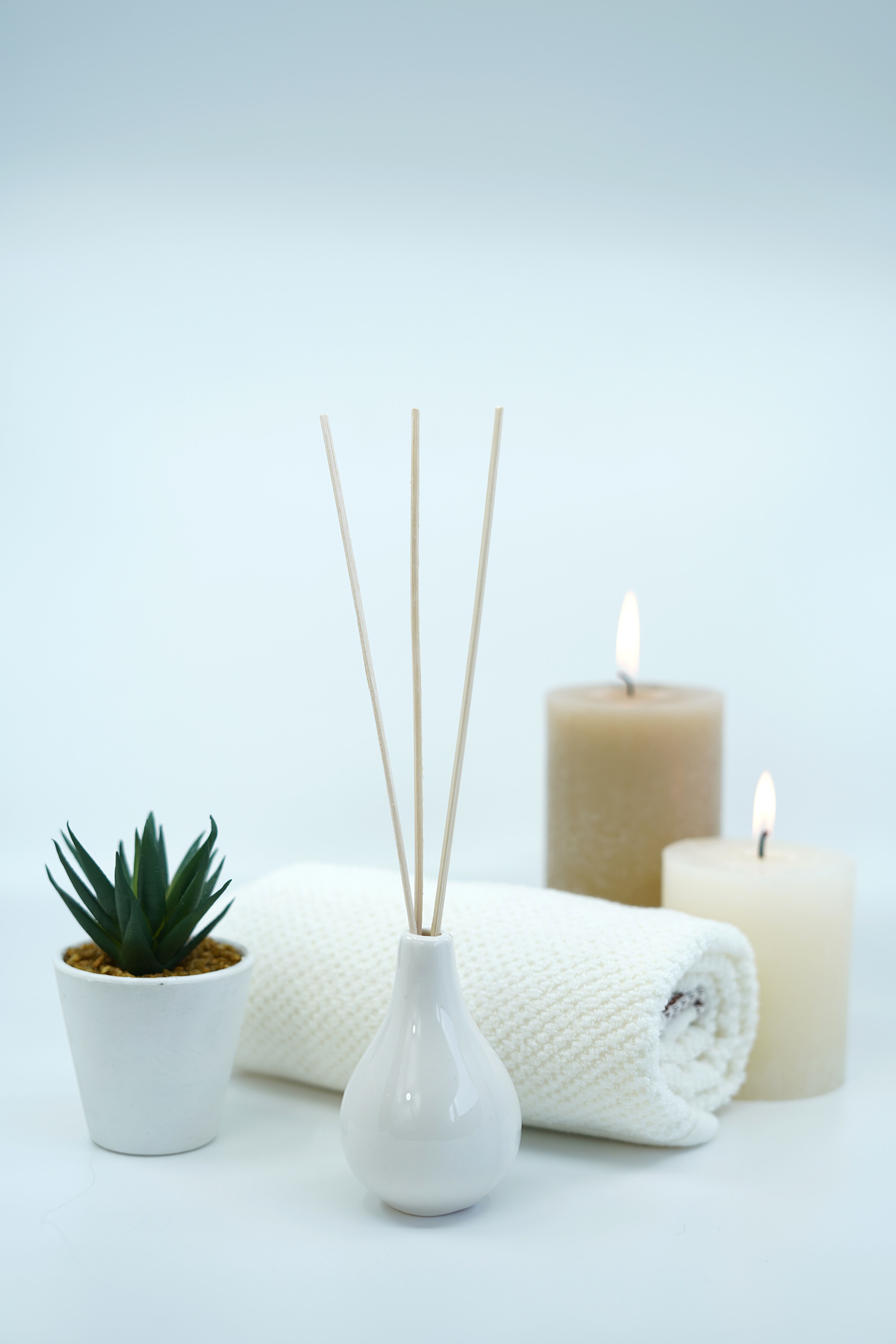 Lit candles, rolled up towel, and incense for spa treatment 