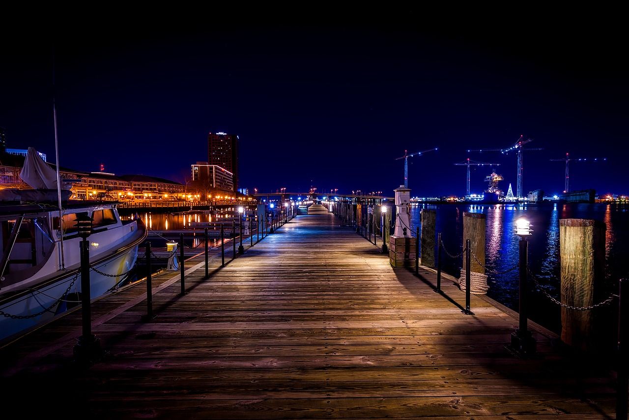 Norfolk, Virginia, Harbour e Boardwalk à noite com a cidade ao fundo