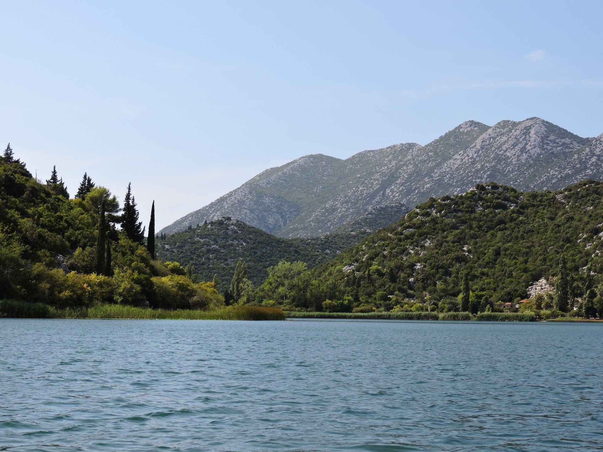 Lago cercado por montanhas e colinas arborizadas