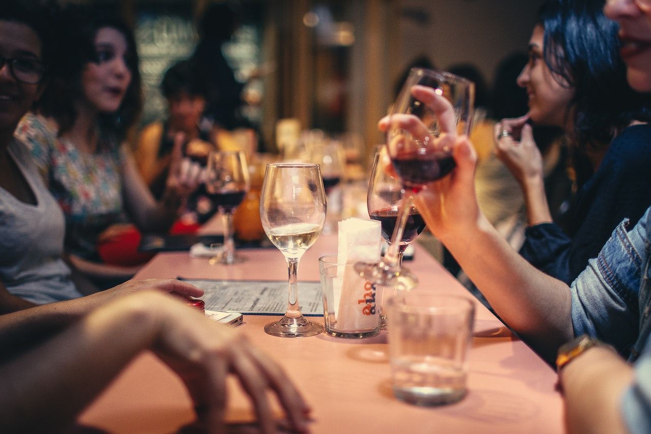 Pessoas bebendo vinho e conversando em um bar 