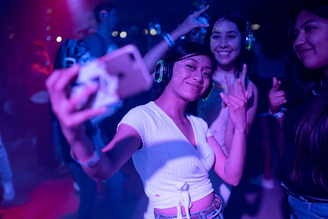 Uma mulher tirando selfie em um clube