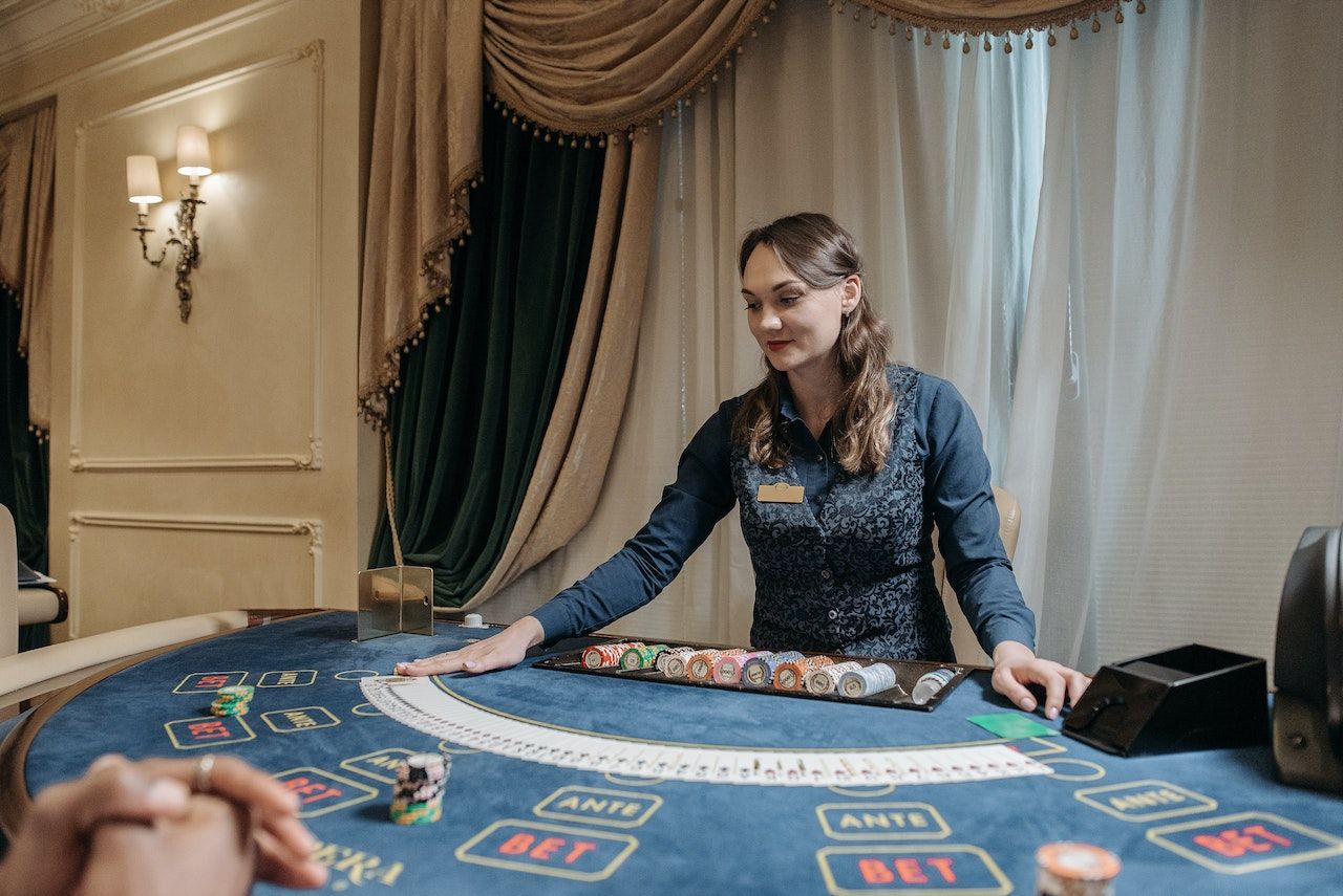 Uma mulher distribuindo cartas em uma mesa de jogo