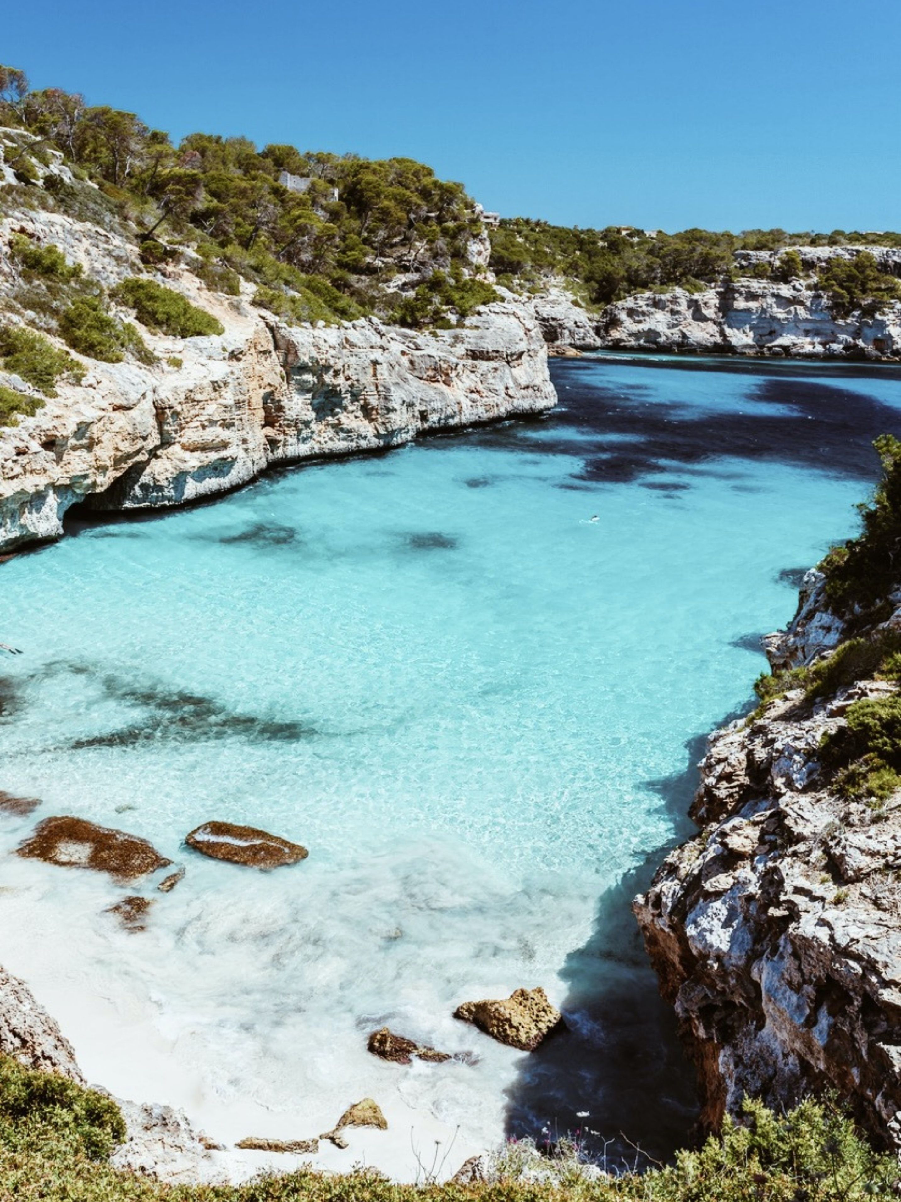 A stunning cove and white sand beach with turquoise ocean in Mallorca, Spain