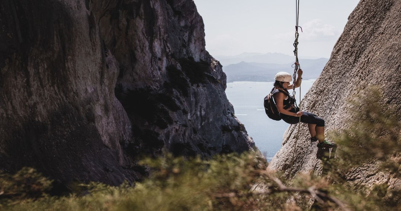 A woman rock climbing in Sardinia, Italy