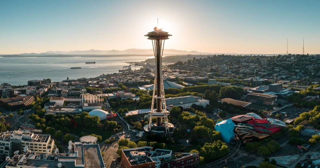 The Seattle Space Needle against Elliot Bay, with Olympic National Park in the distance