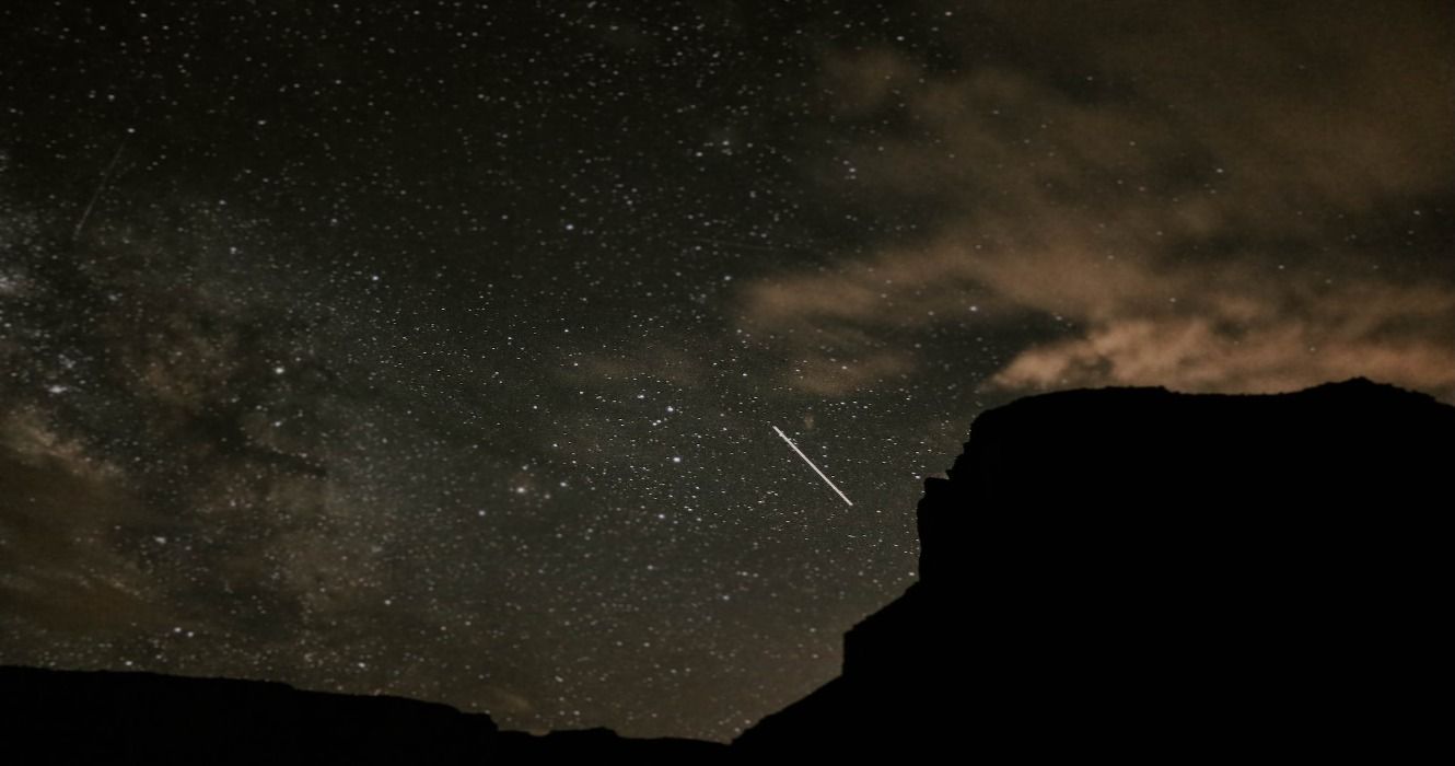 A shooting star against a starry night sky in the Moab desert in Utah, USA