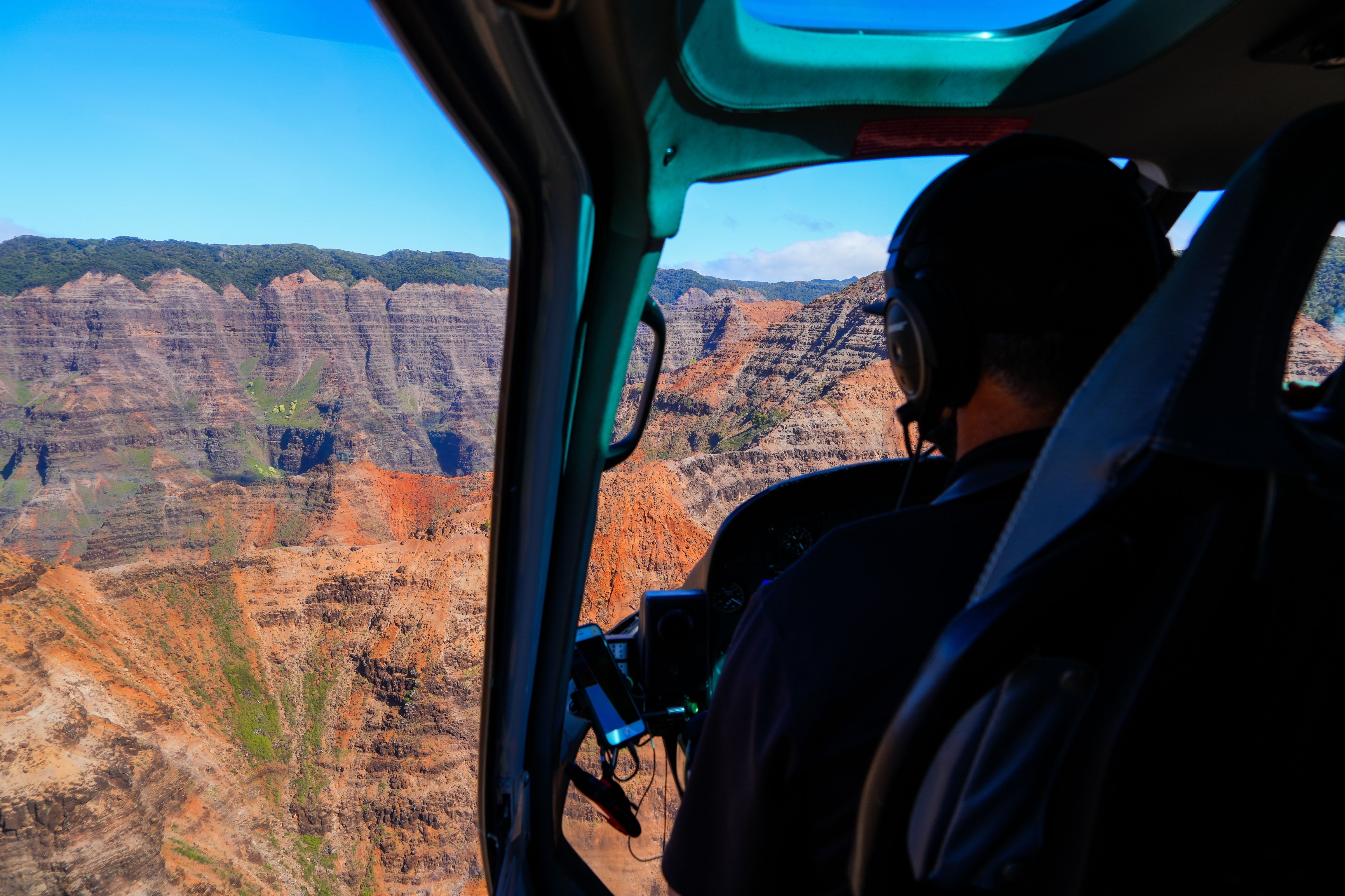 Piloto voando de helicóptero sobre Waimea Canyon State Park