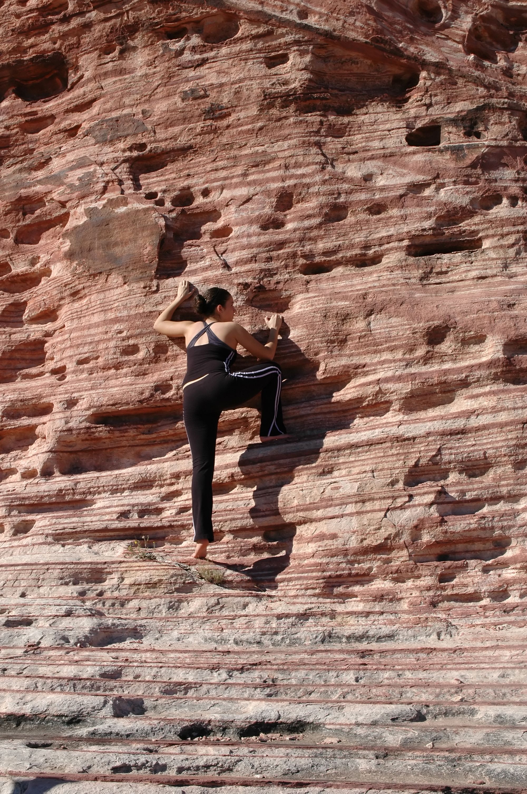 Uma garota escalando uma parede de pedra em Red Rock Canyon, Nevada