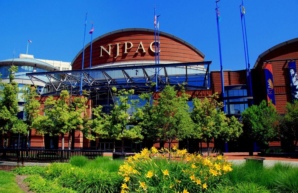 Yellow Day Lilies and trees in front of the New Jersey Performing Arts in Newark, New Jersey. 