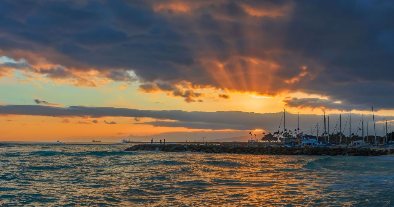 Stunning sunset with sunbeams shining through storm clouds in Waipahu, Oahu, Hawaii