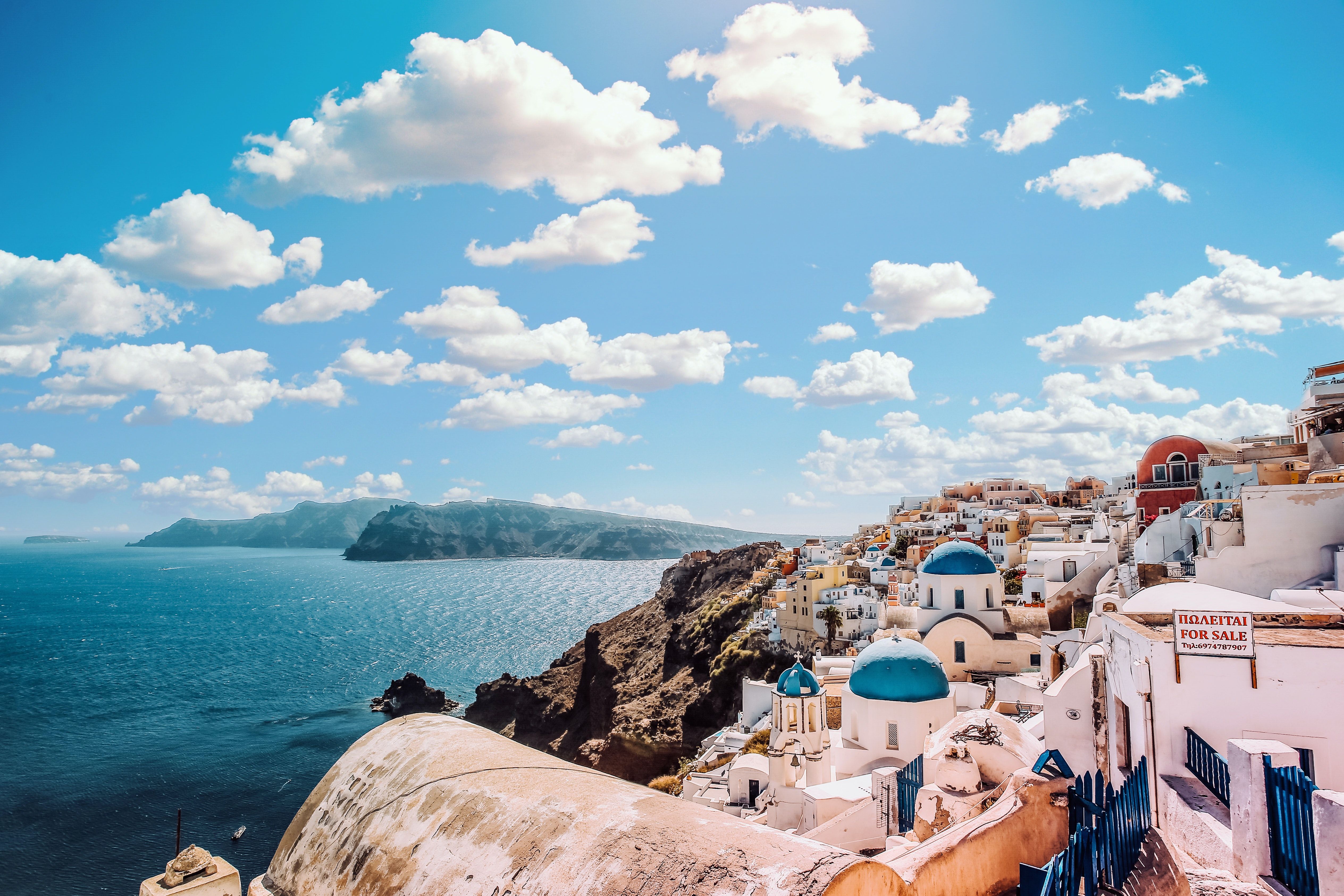 Clouds over the houses and blue-domed buildings in Santorini, Greece