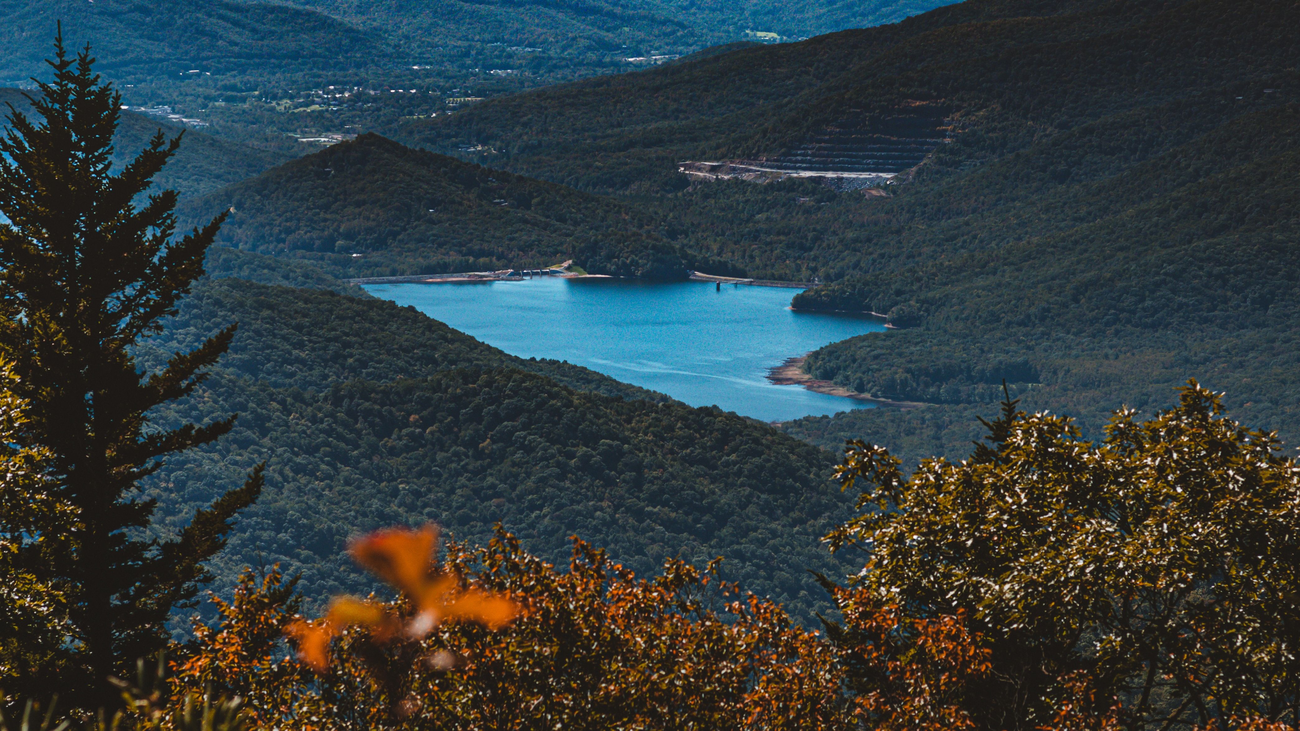 Montanhas cobertas de árvores revelam um lago azul 