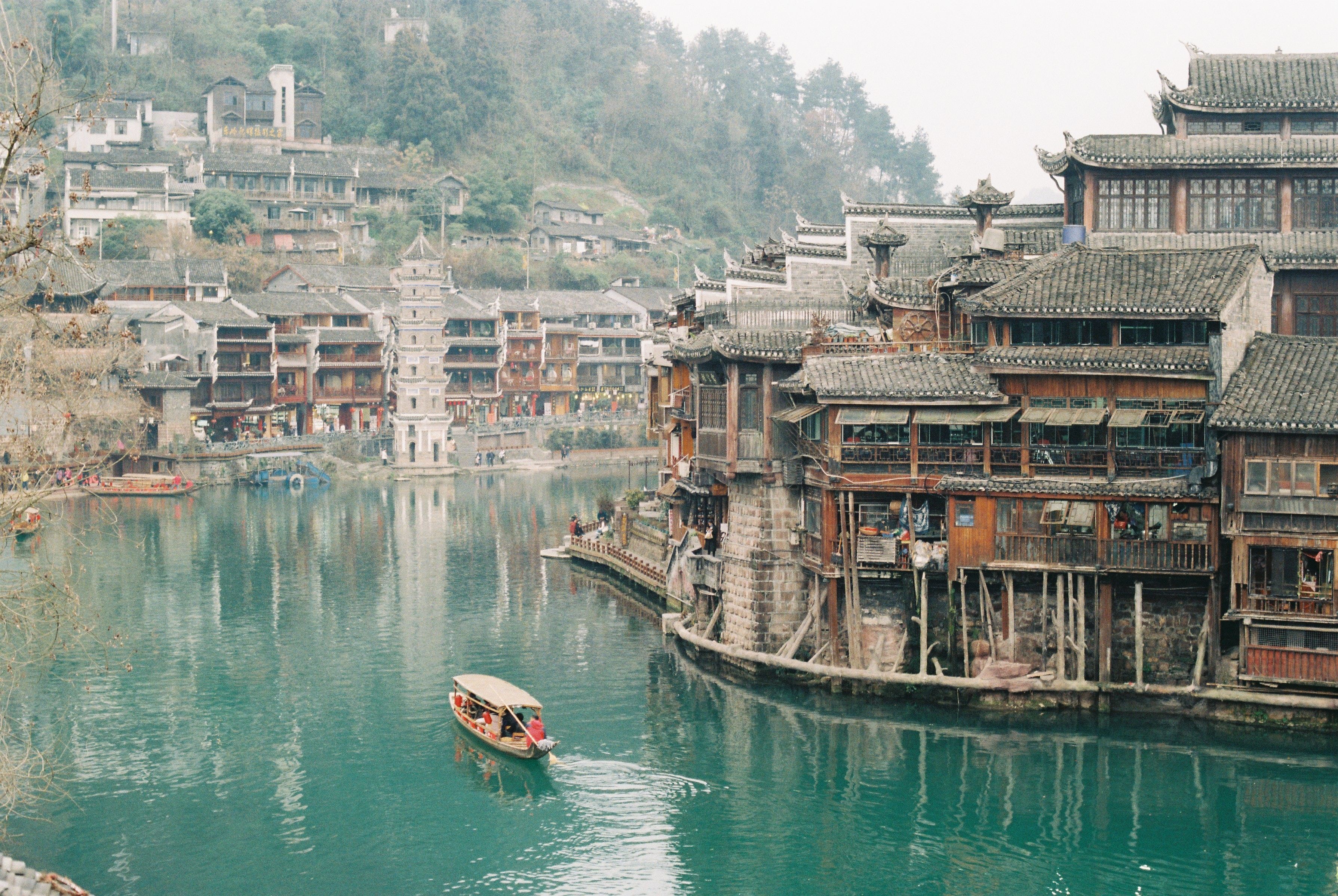 Um barco fluvial navegando em um rio na província de Fenghuang, China