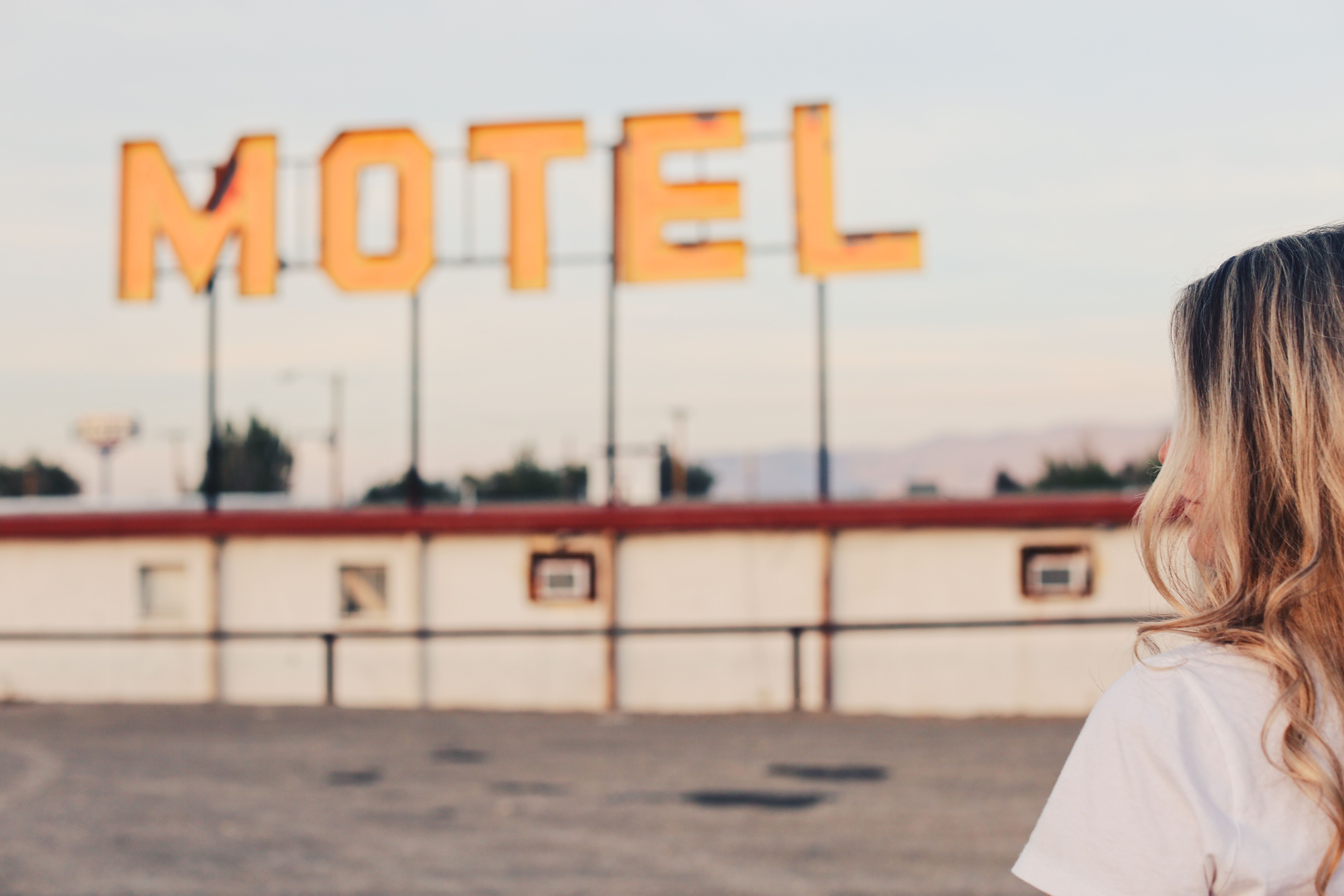 A woman in front of a Motel sign