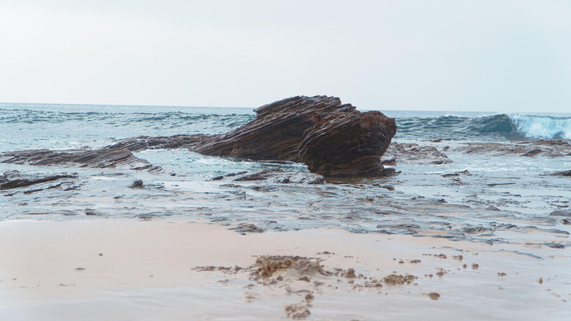 Rock formations in the shore of a wavey beach
