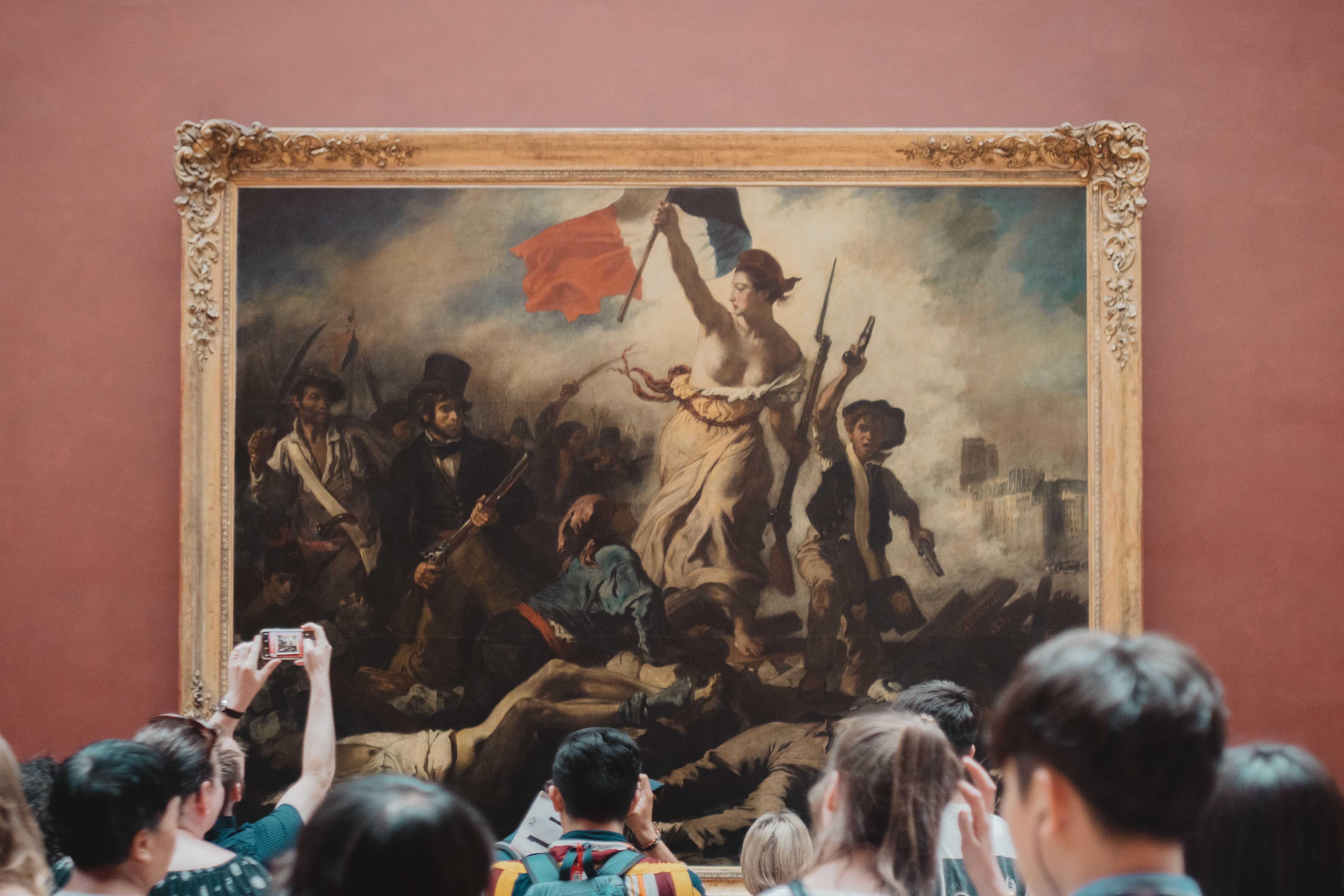 People taking pictures of Liberty leading the people at the Louvre Museum