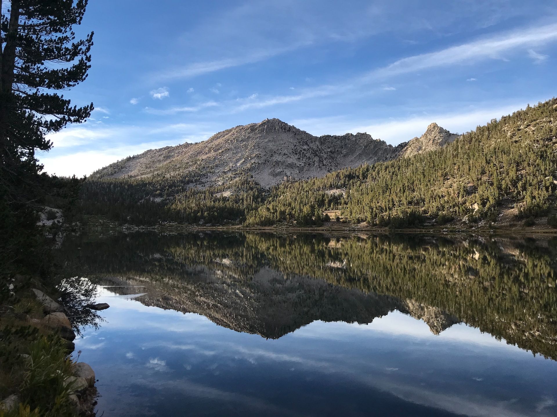 Mountains and trees of Kings Canyon being reflected on Charlotte Lake