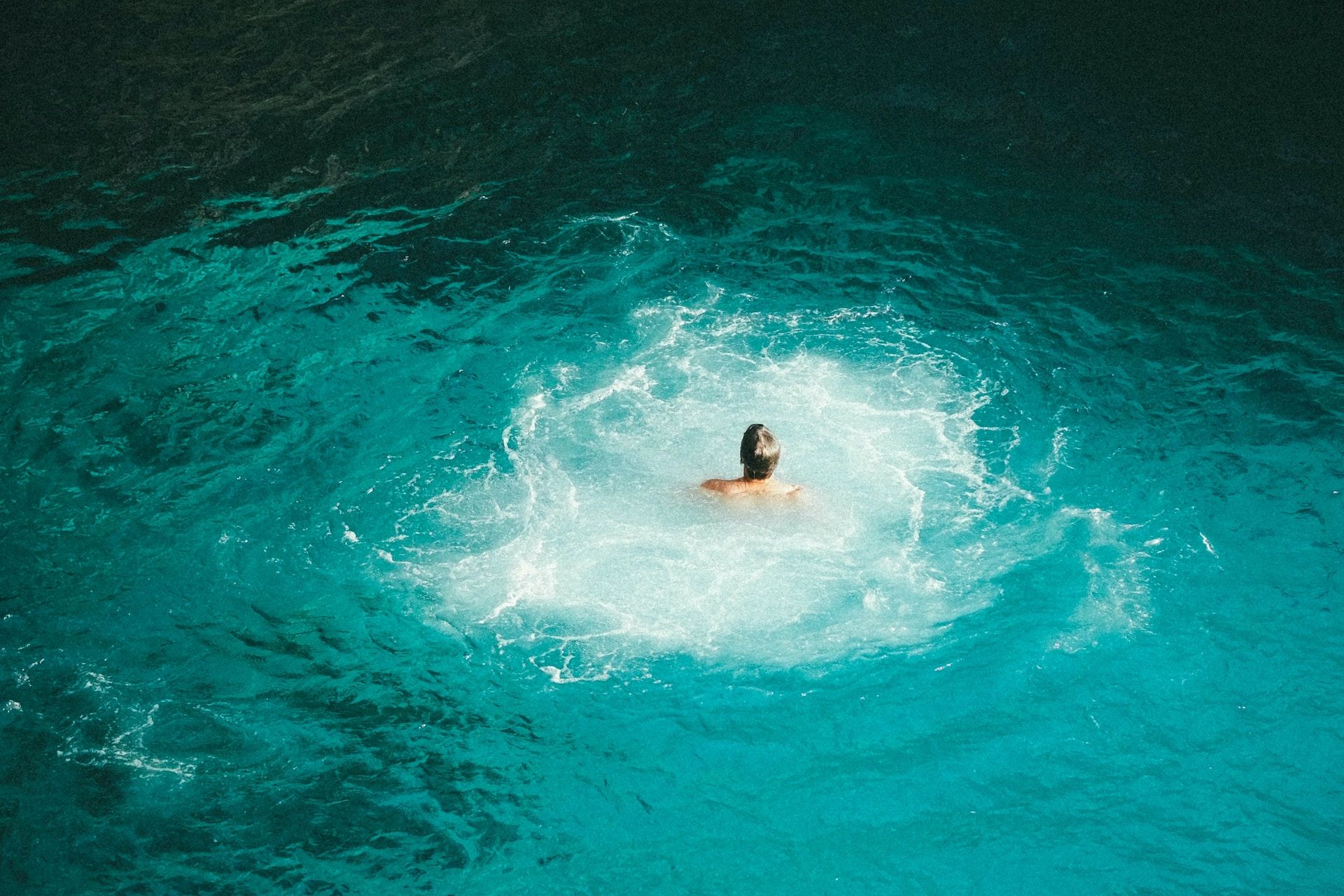 A person swimming in the blue water in Negril, Jamaica