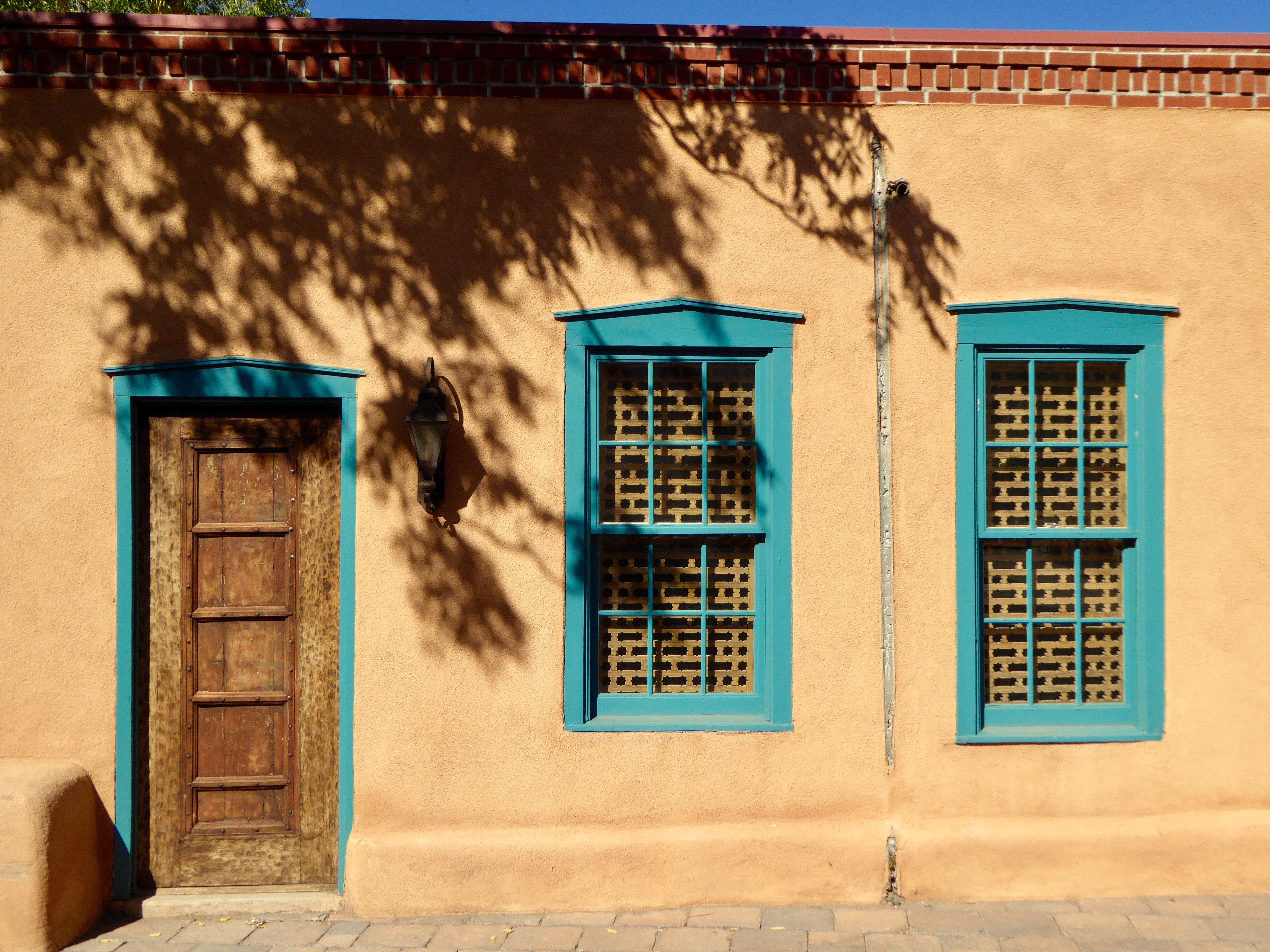 Edifício de estilo Pueblo cor de areia com detalhes em azul 
