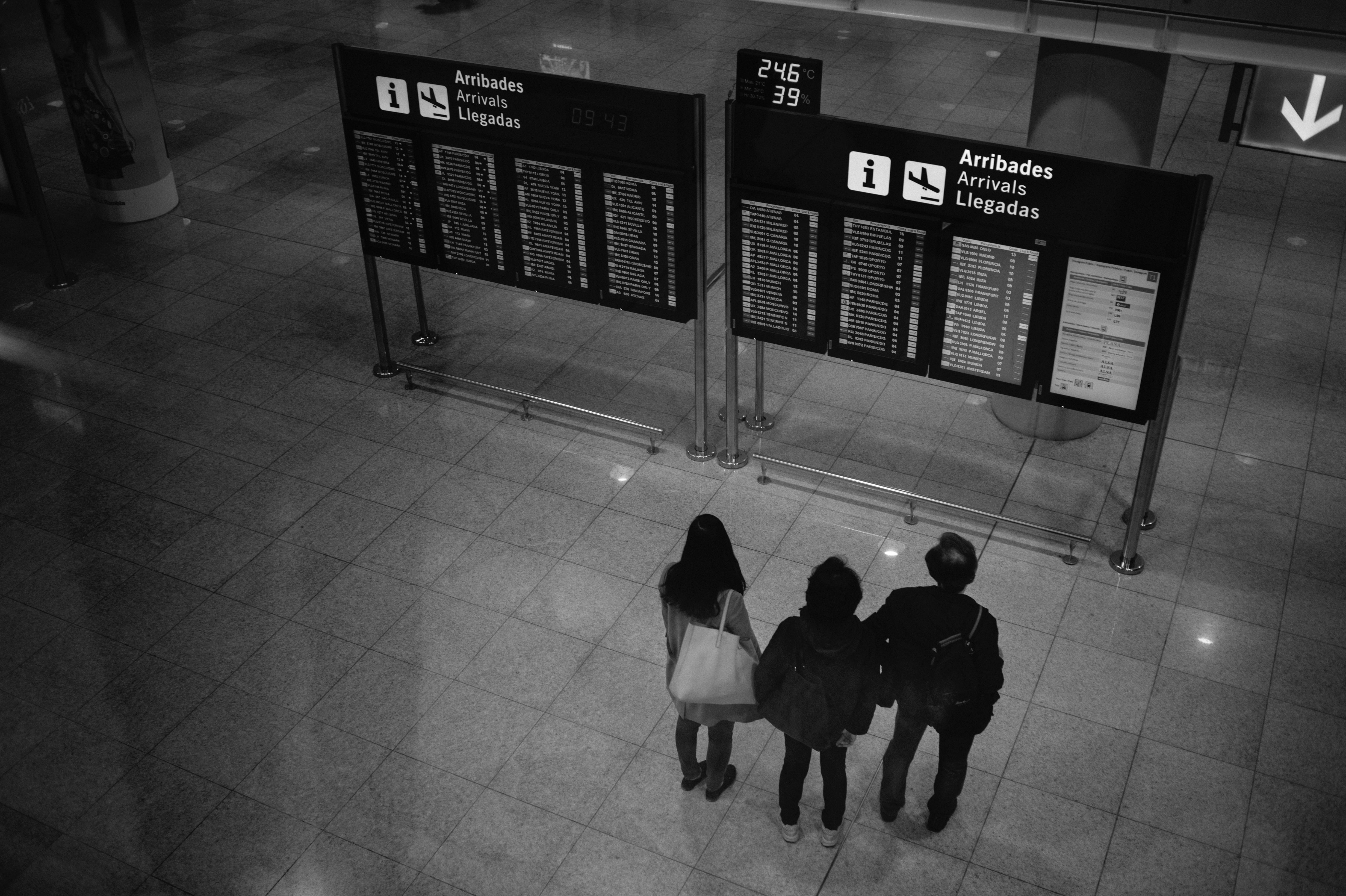 Travelers looking at the arrivals board at the Barcelona-El Prat airport.