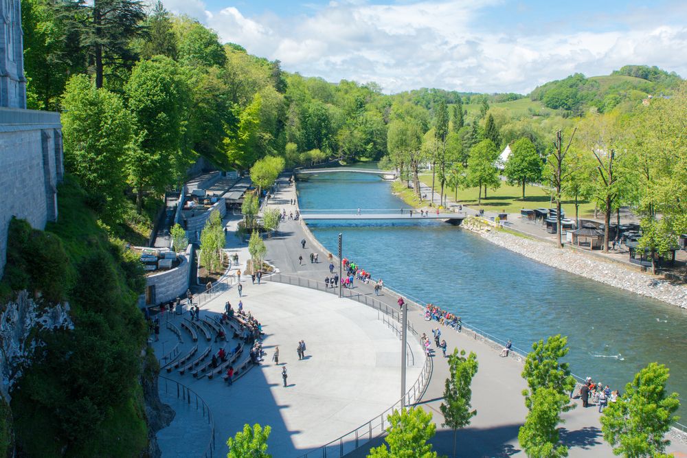 People next to a river canal in Lourdes
