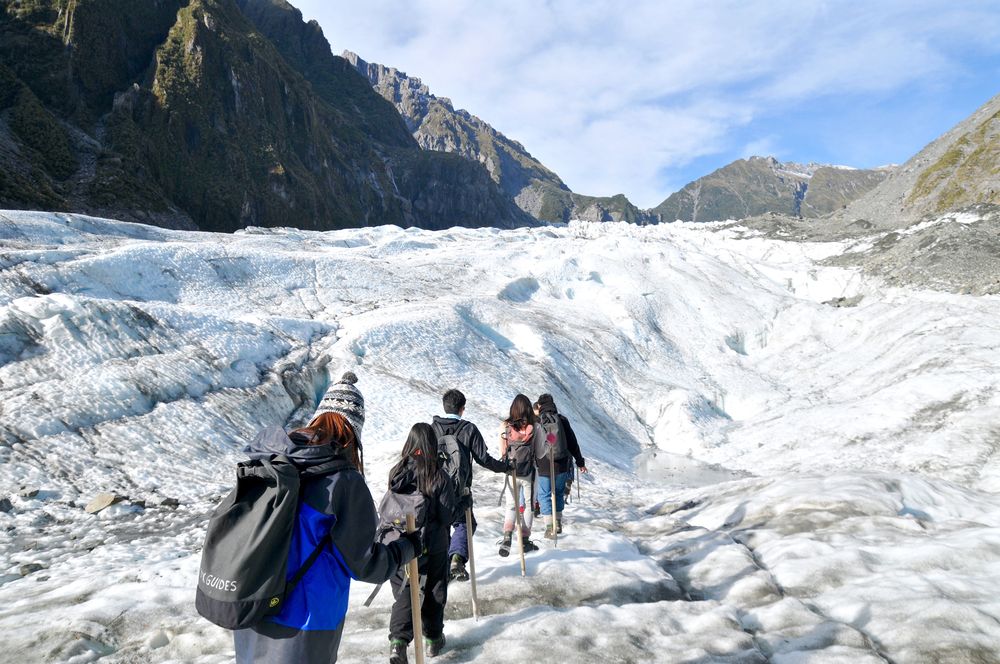Tourists trekking at Fox Glacier, New Zealand