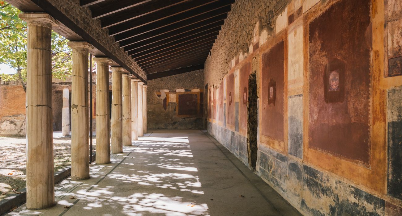  The image shows a long廊柱 with colorful frescoes on the walls, it was buried by the eruption of Mount Vesuvius in 79 AD and excavated in the 18th century.