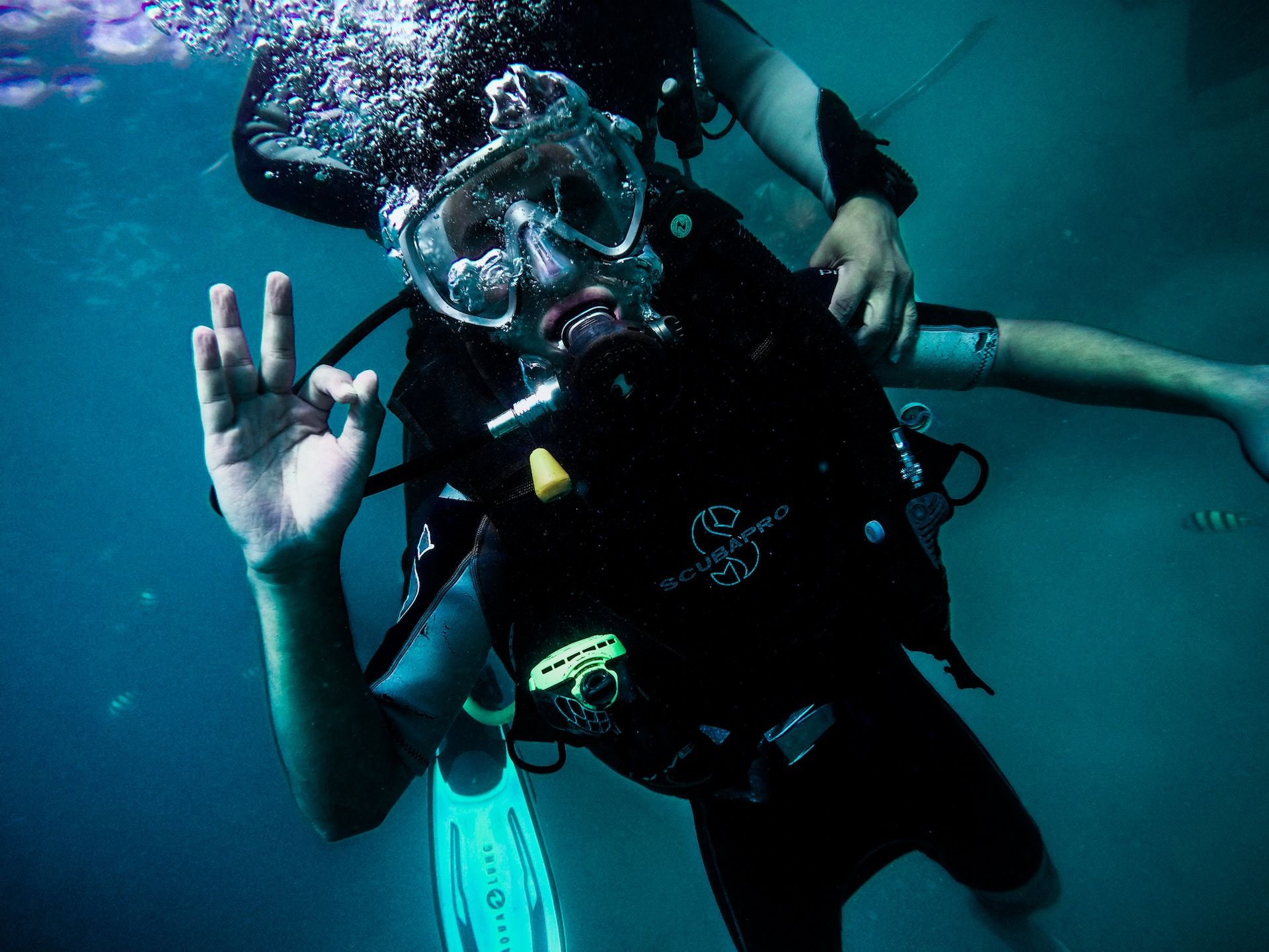 Scuba diver in water showing the okay sign 
