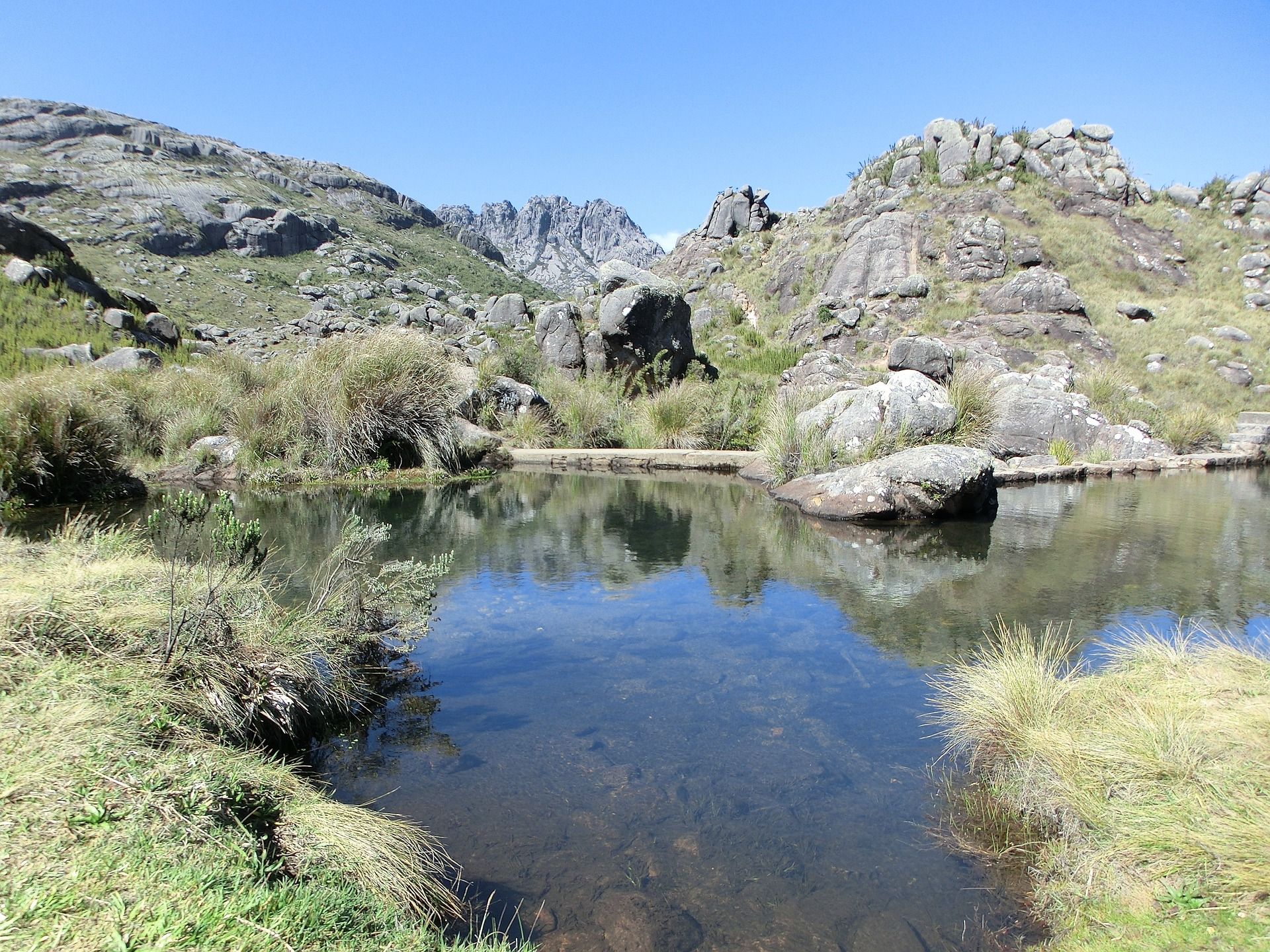 A waterbody surrounded by rocks under a blue sky in Itatiaia National Park Brazil 